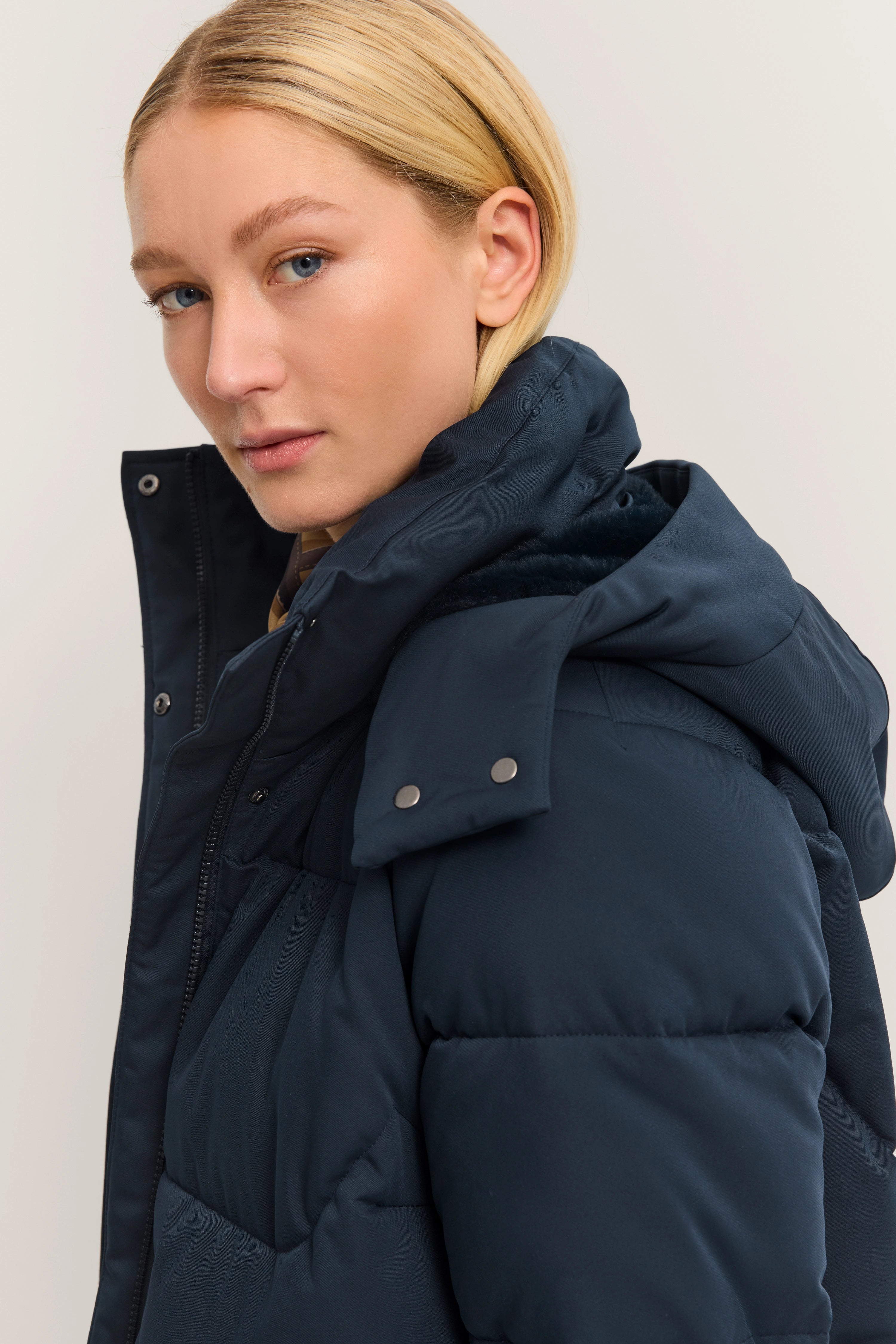 Dunkelblaue bugatti Daunenjacke, Modelbild im Seitenprofil.