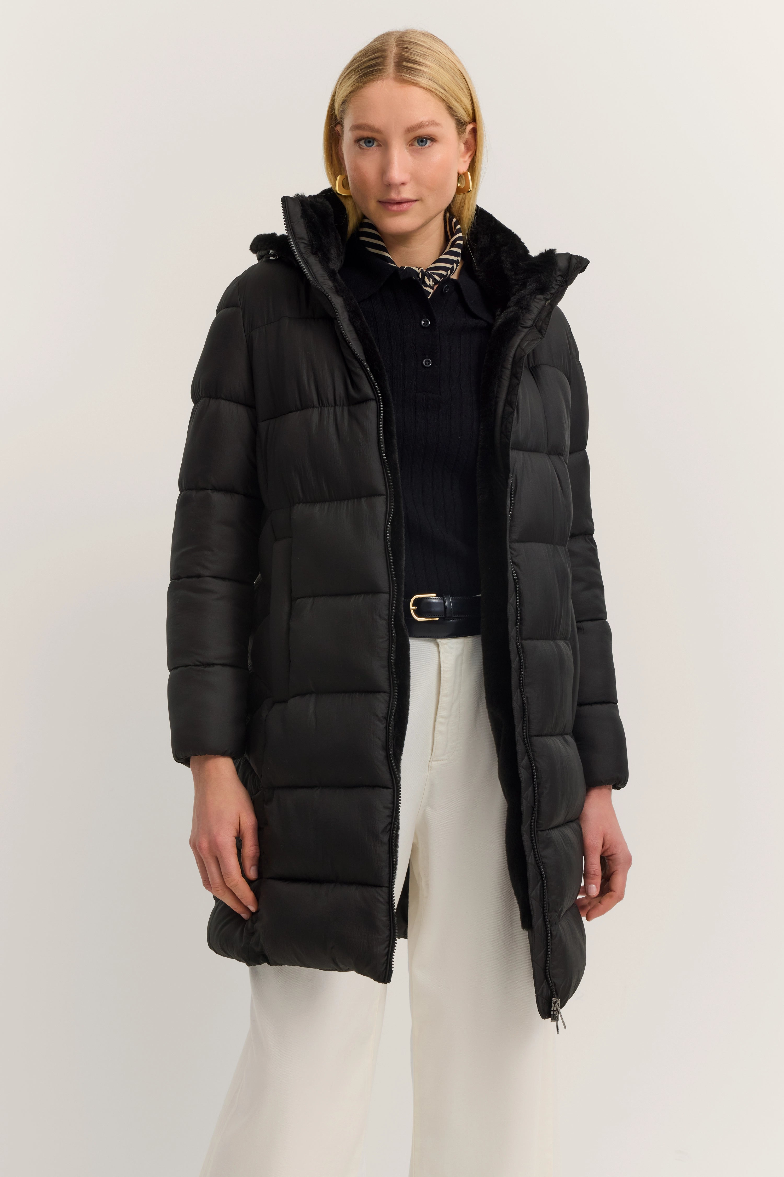 Schwarzer bugatti Daunenmantel, Modelbild, lässige Pose, kombiniert mit schwarzem Pullover und weißer Hose.
