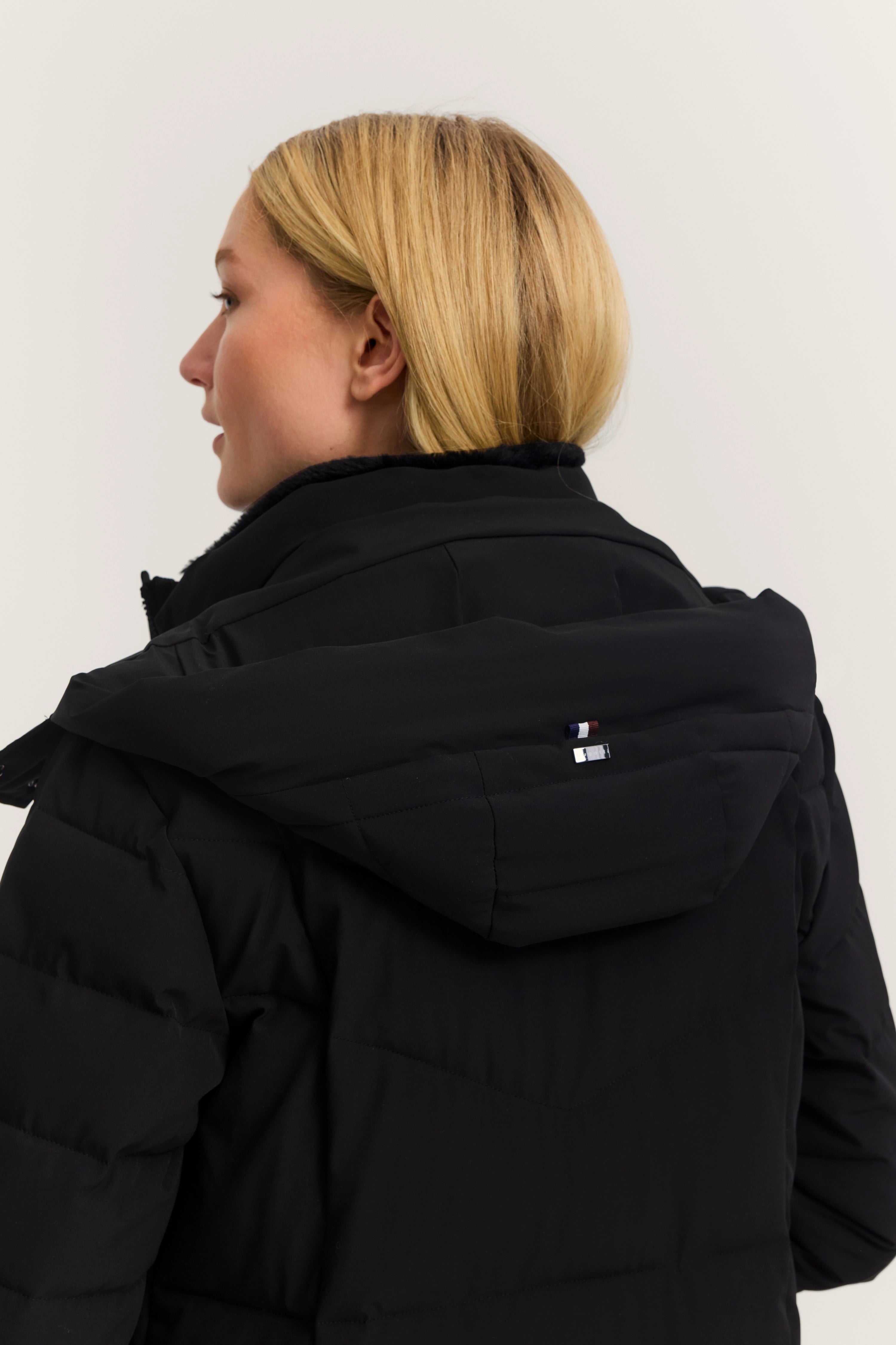 Schwarze bugatti Jacke mit Kapuze, Model von hinten, lässiger Look.