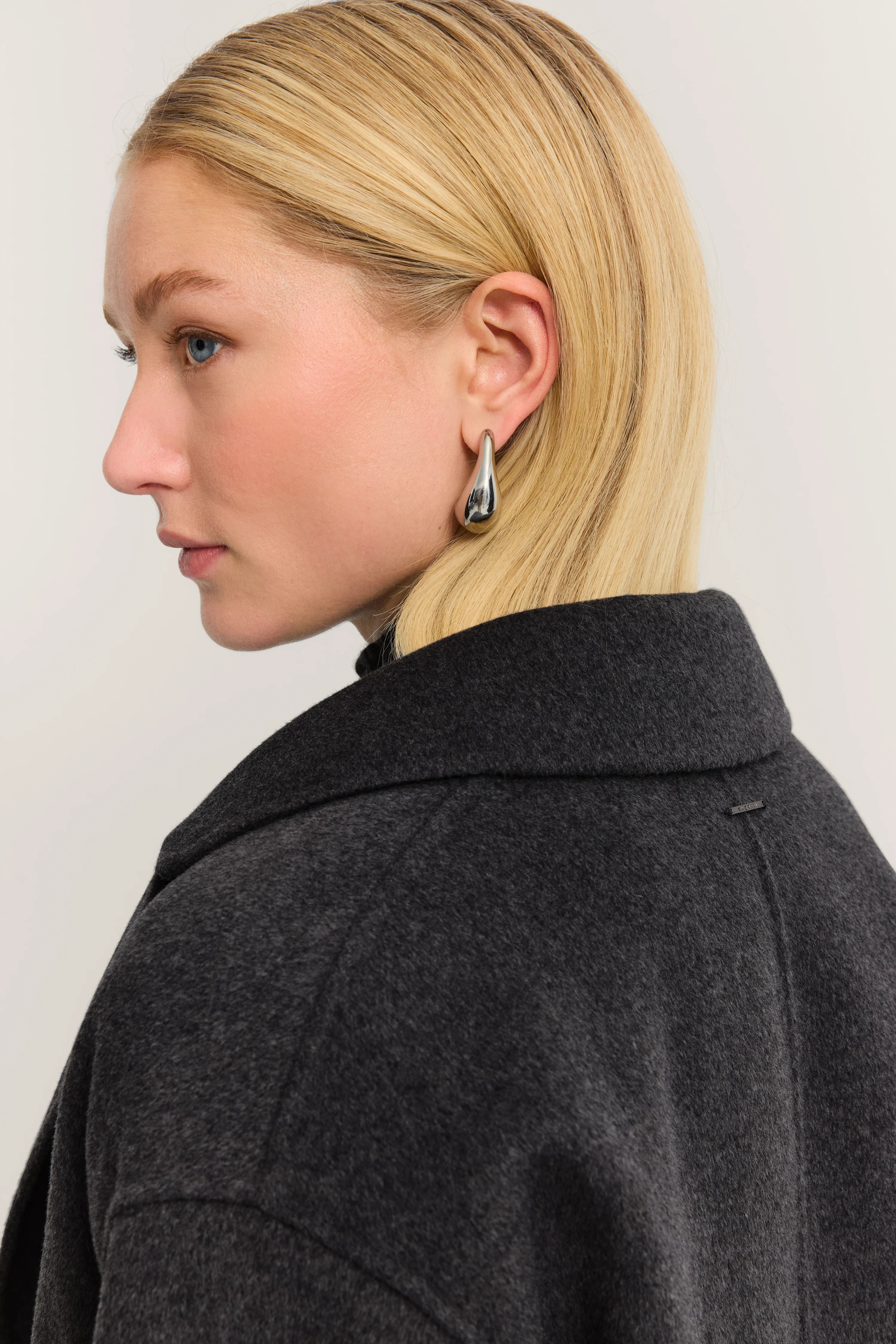 Grijze wollen jas van bugatti, zijaanzicht, elegant profiel, subtiele elegantie en stijl.