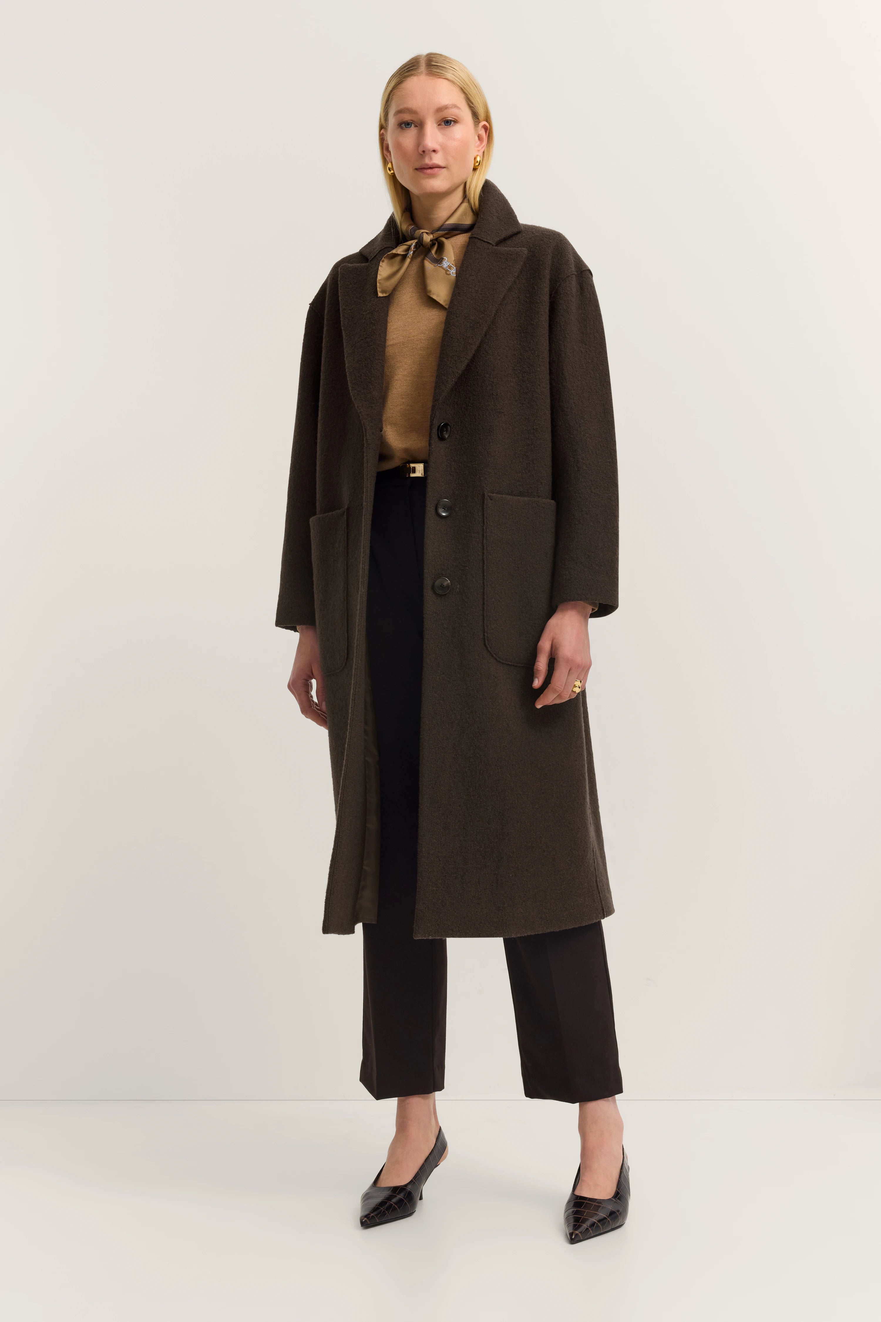 Brauner Mantel, beige Pullover, schwarze Hose, Halstuch