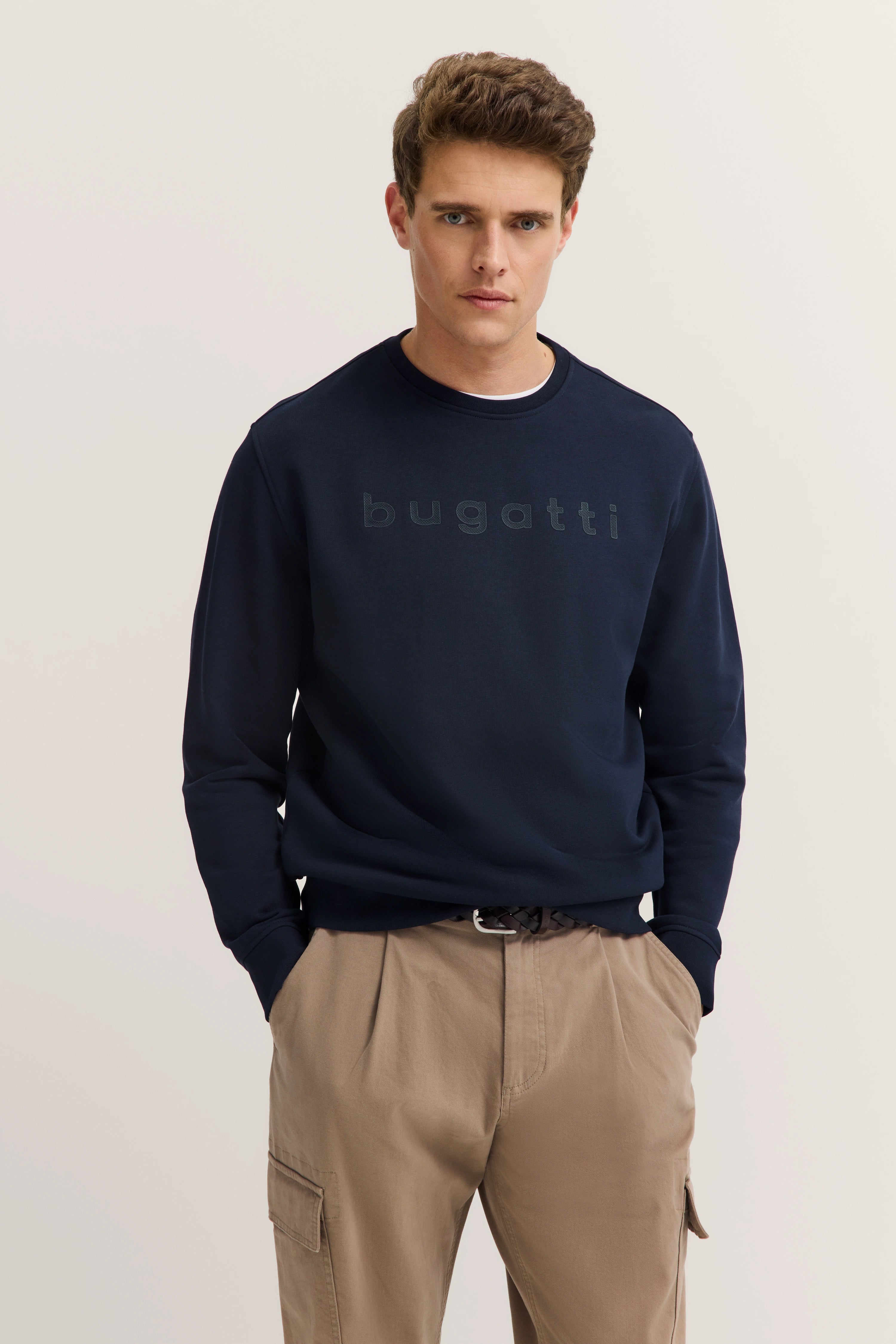 Navy bugatti Pullover, beige Hose, Modelbild, entspanntes Posing.