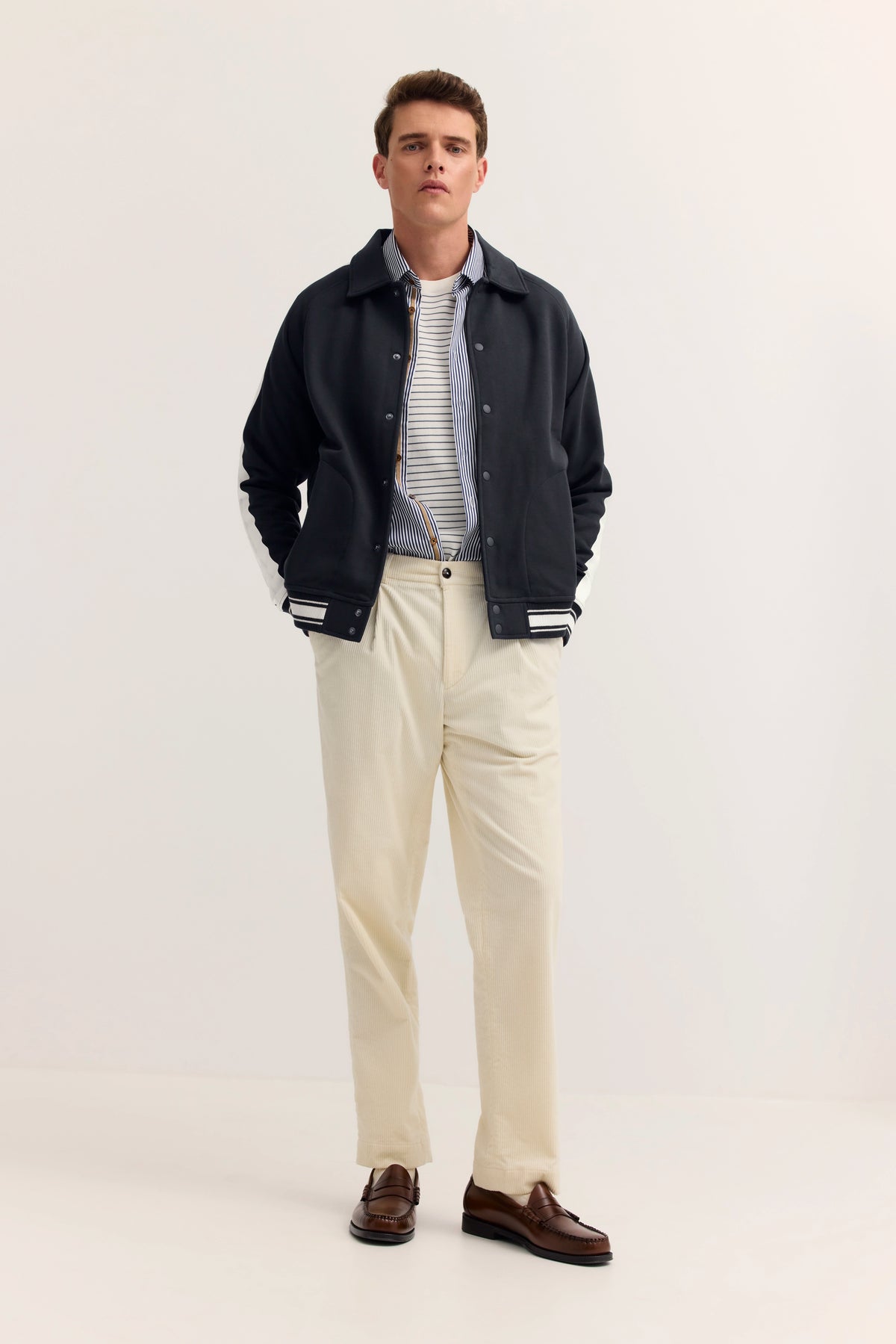 Dunkelblaue bugatti Jacke mit weißen Streifenbündchen, legeres Büstenbild.
