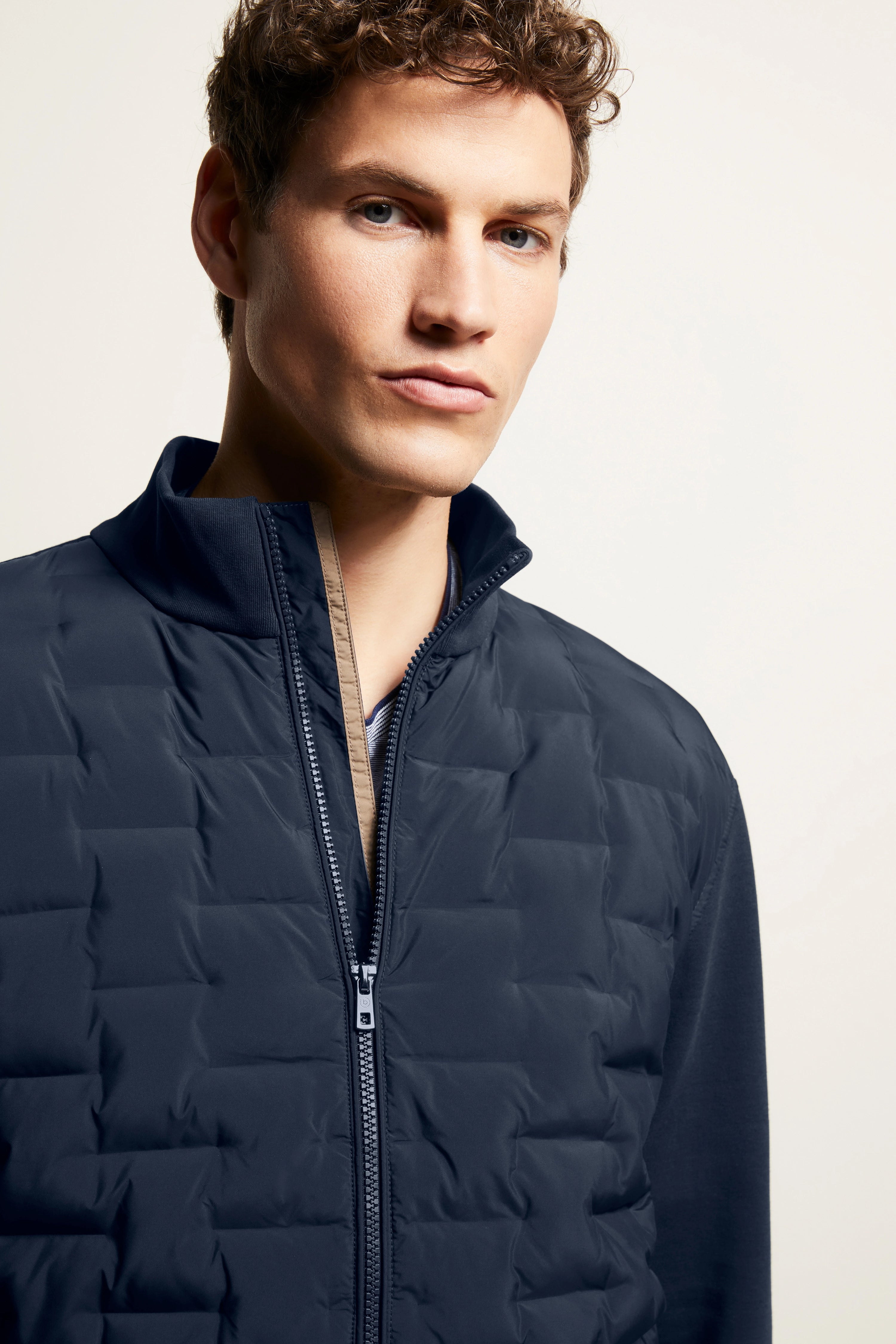 Büstenbild eines Mannes in dunkelblauer bugatti-Steppjacke, stilvoll und zeitlos elegant.