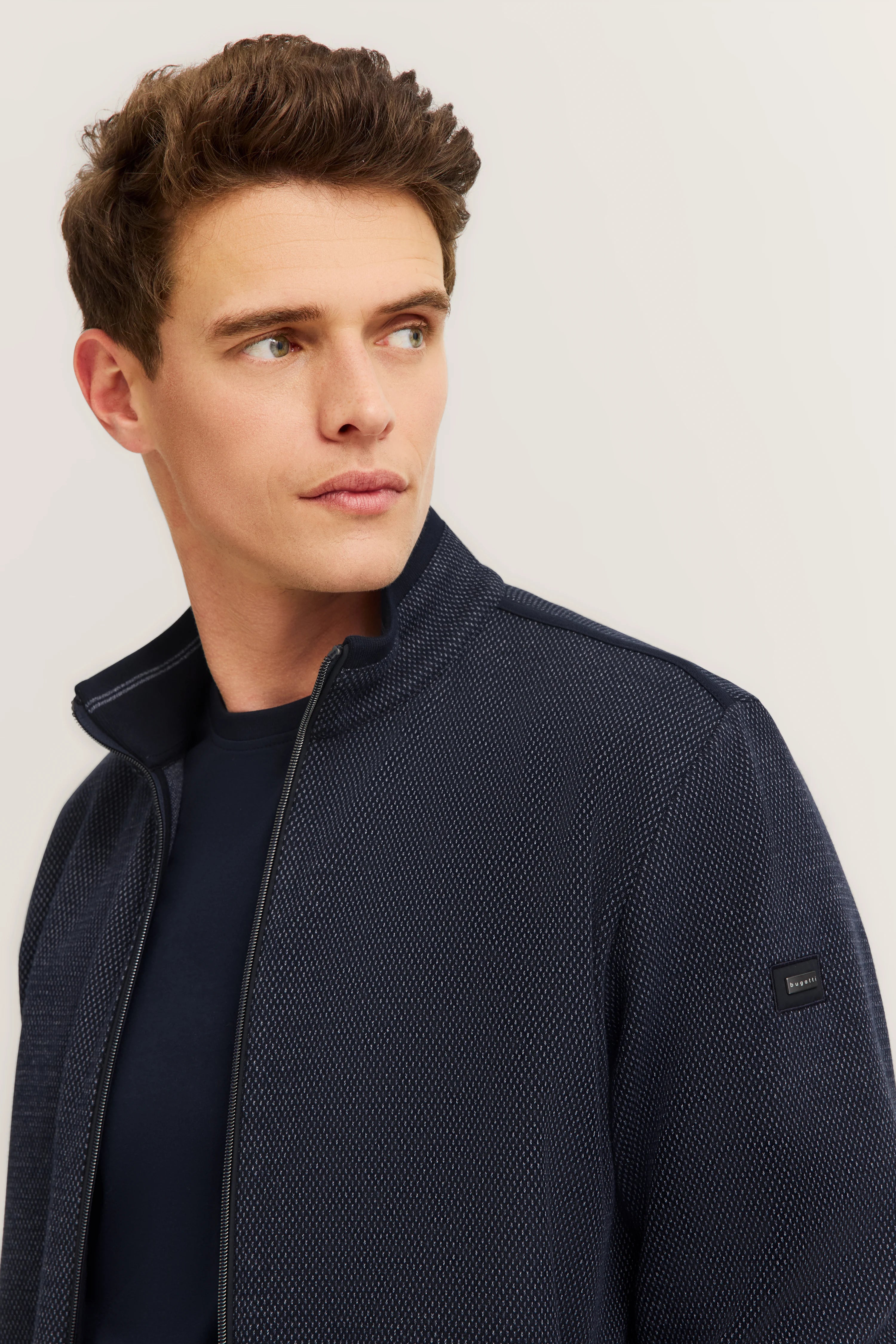 Navy Strickjacke von bugatti, Modelbild im Halbprofil, eleganter Stil, zeitlos und raffiniert.