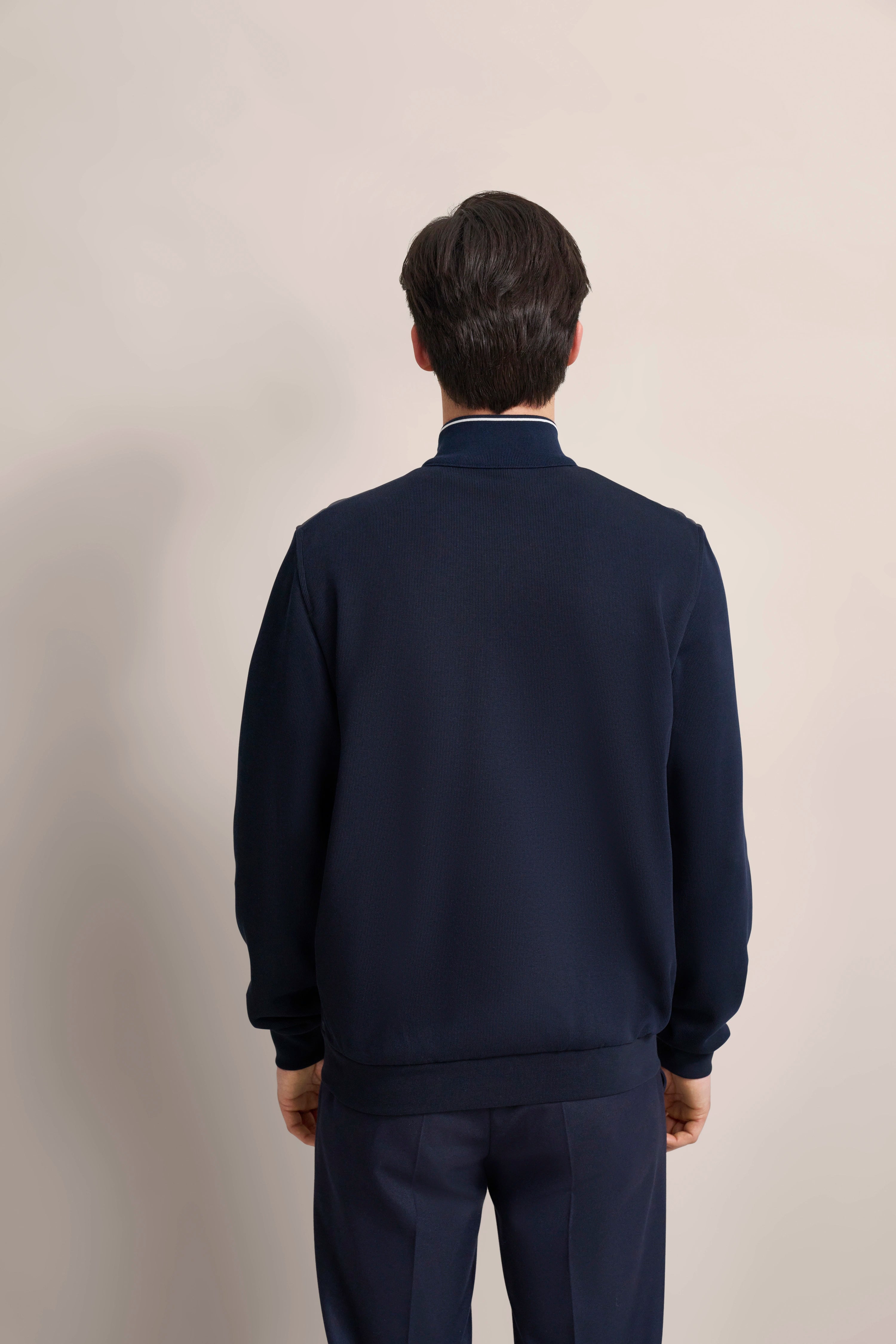 Navyblauer bugatti Pullover und Hose, Rückansicht, Modelbild.