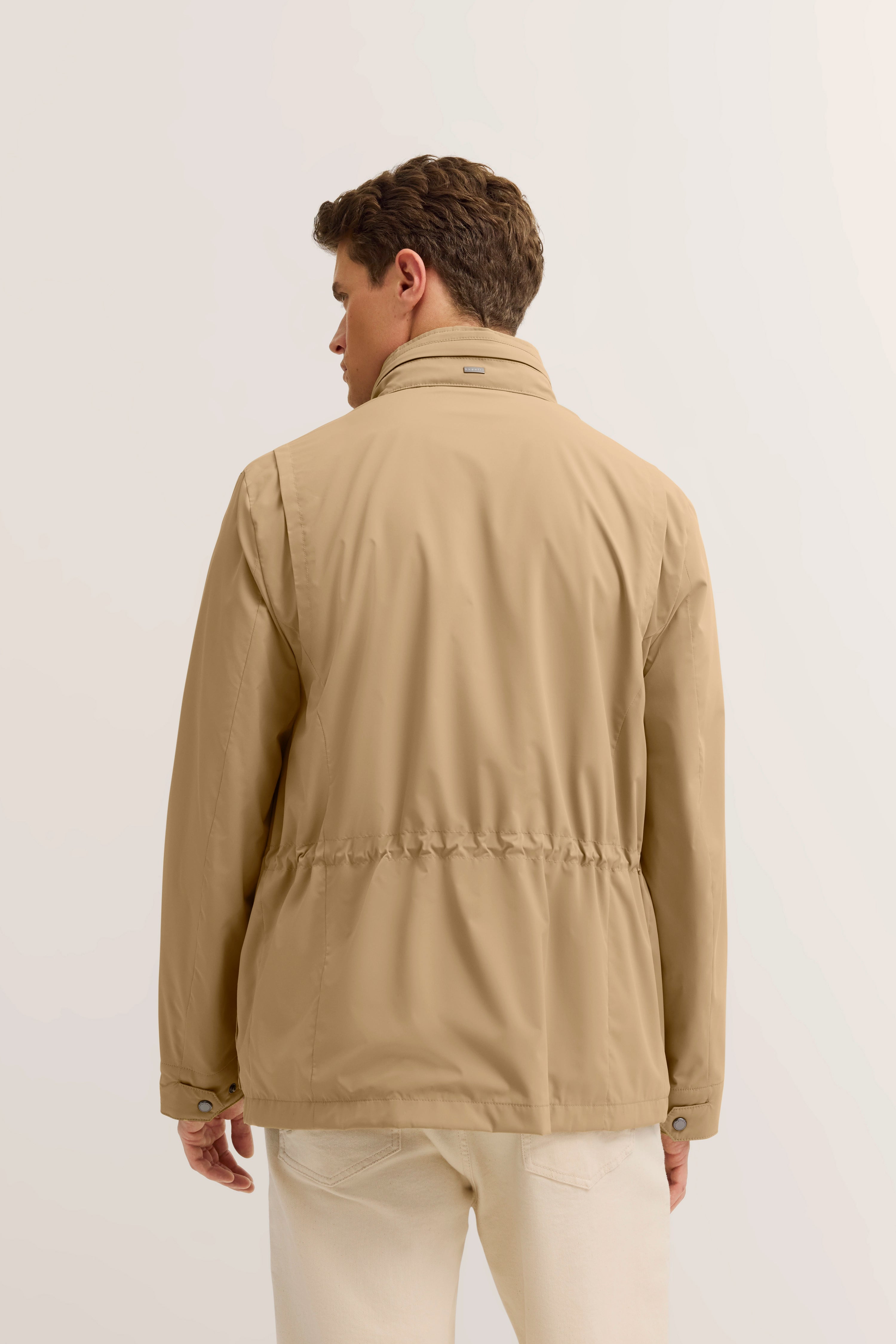 Beigefarbene bugatti-Jacke, Rückansicht, Modelbild, lässiger Stand, helle Jeans.