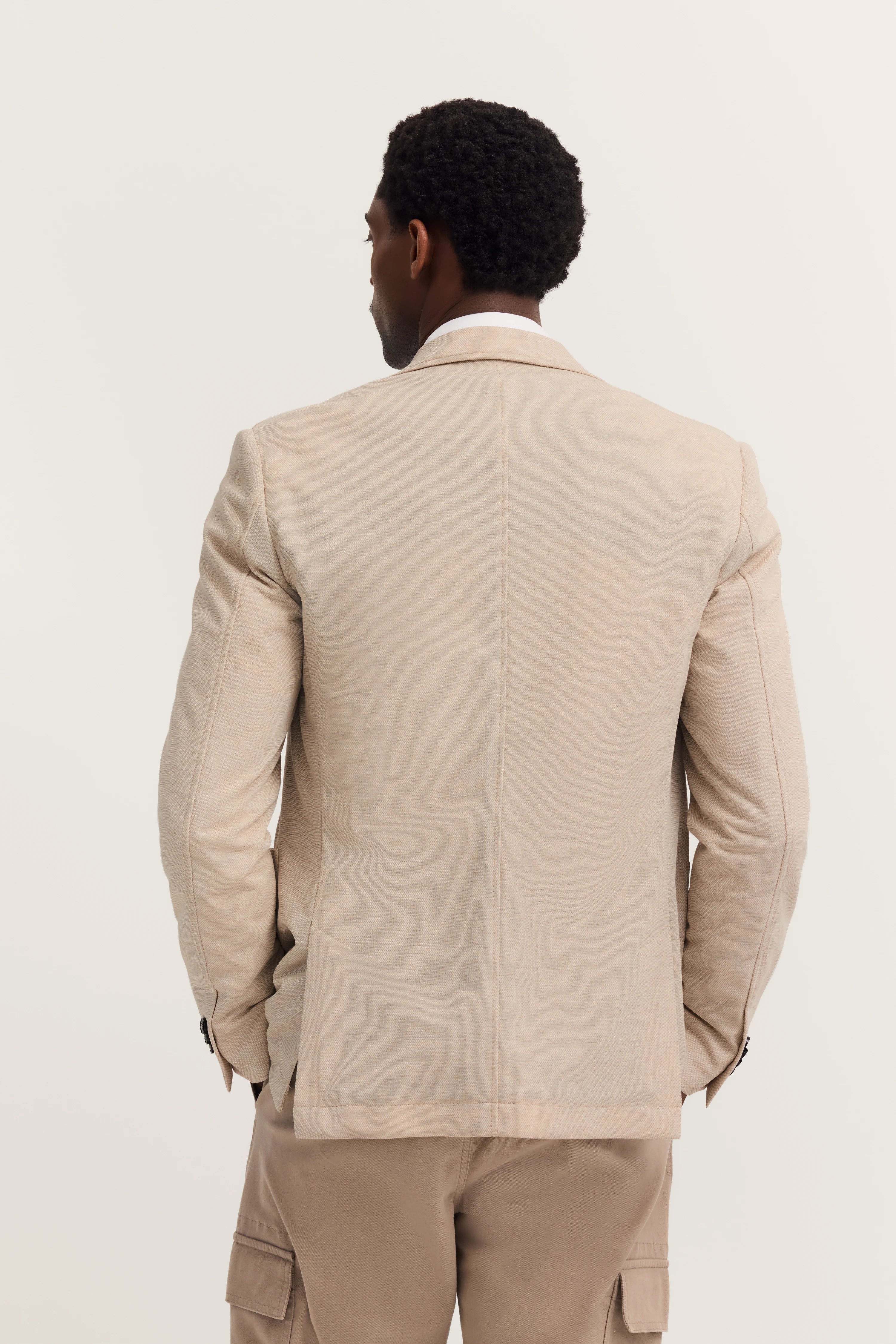 Beige bugatti Sakko, Modellbild von hinten, lässige Pose, kombiniert mit brauner Hose.