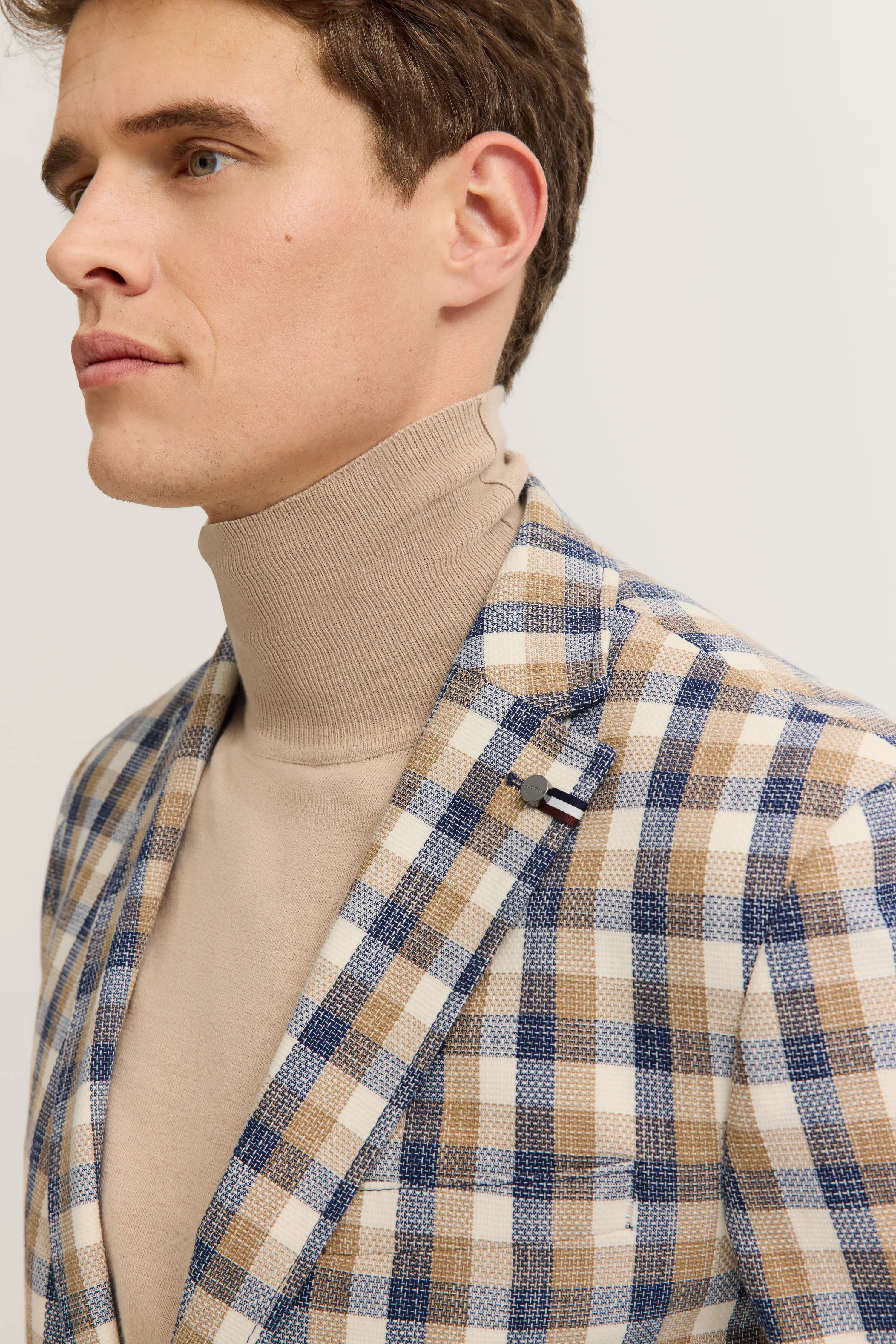 Beige turtleneck with blue and beige checkered blazer, model side view, bugatti style.