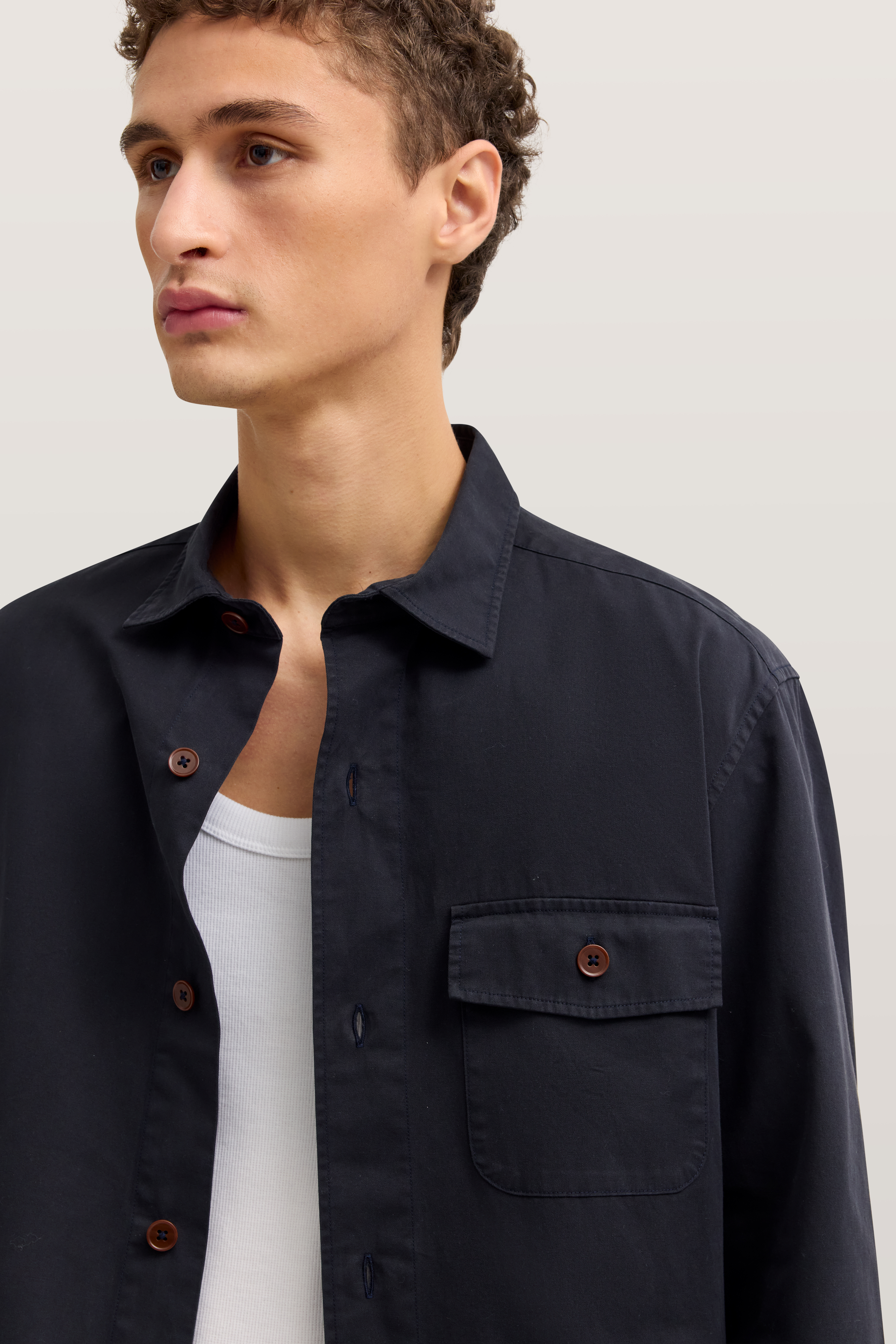 Model trägt schwarzes Hemd von bugatti, Rückansicht, kombiniert mit beige Chinos.