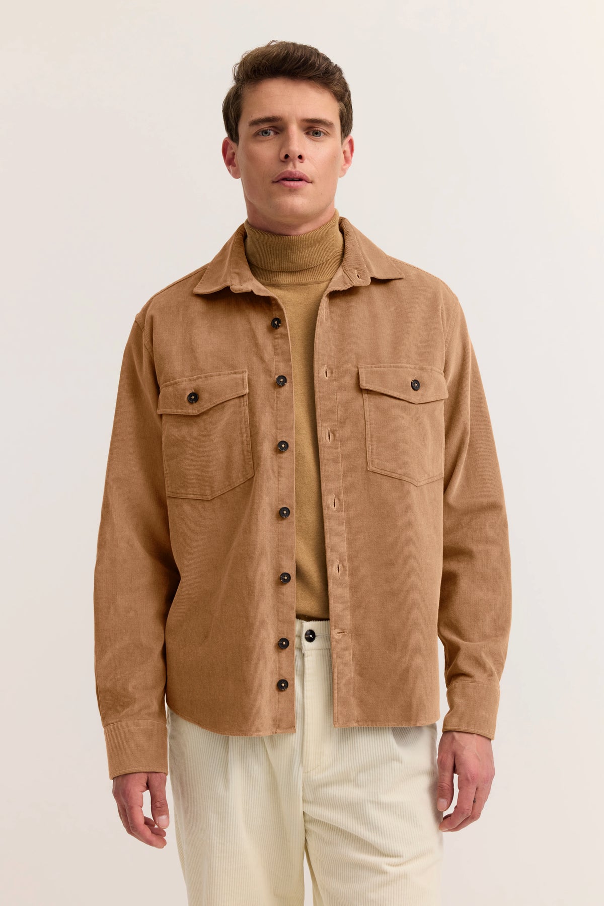 Model trägt camel Cordhemd und Rollkragen, beige Hose