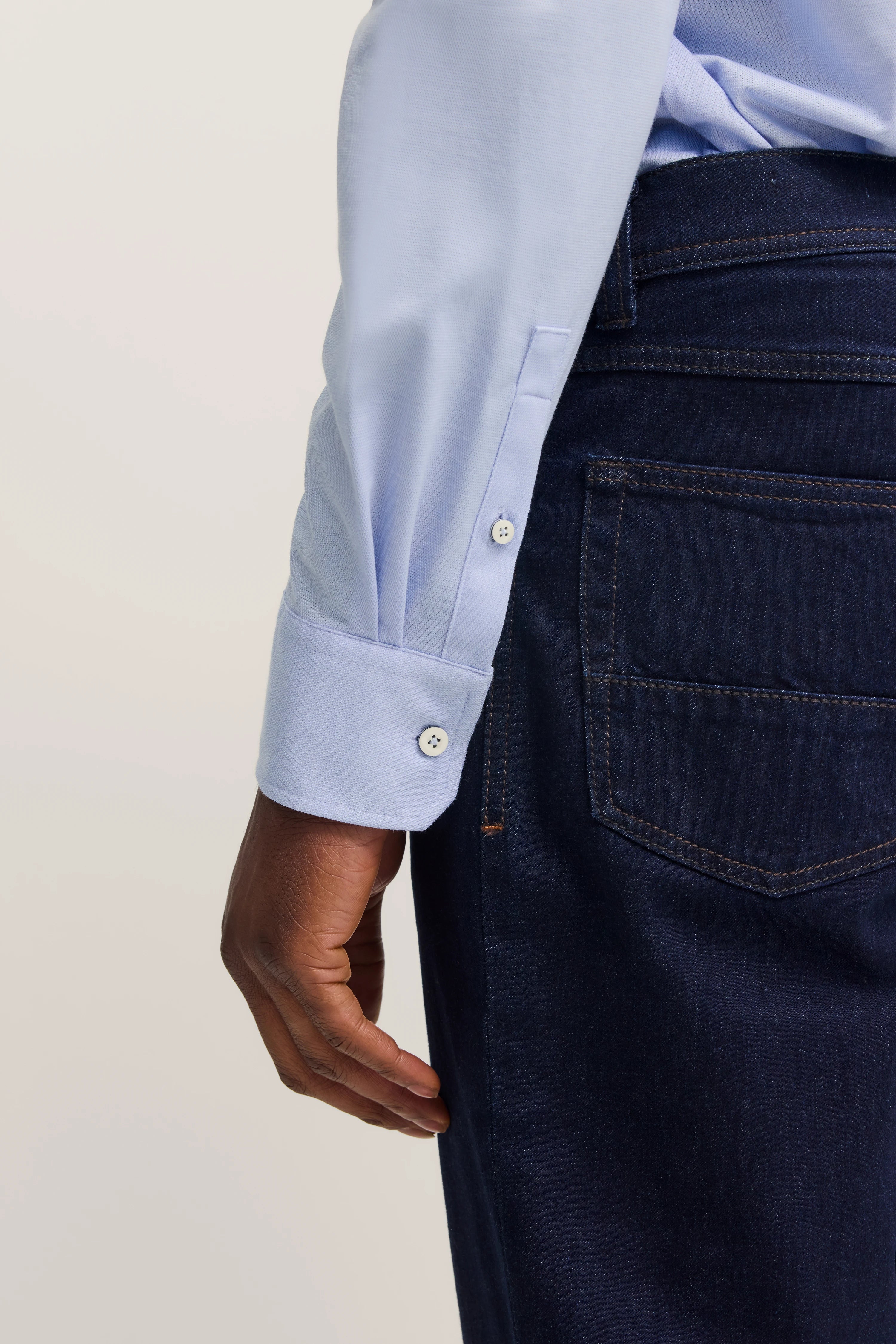 Hemd in Hellblau mit Knopfmanschetten, dunkelblaue Jeans, Detailaufnahme von bugatti.