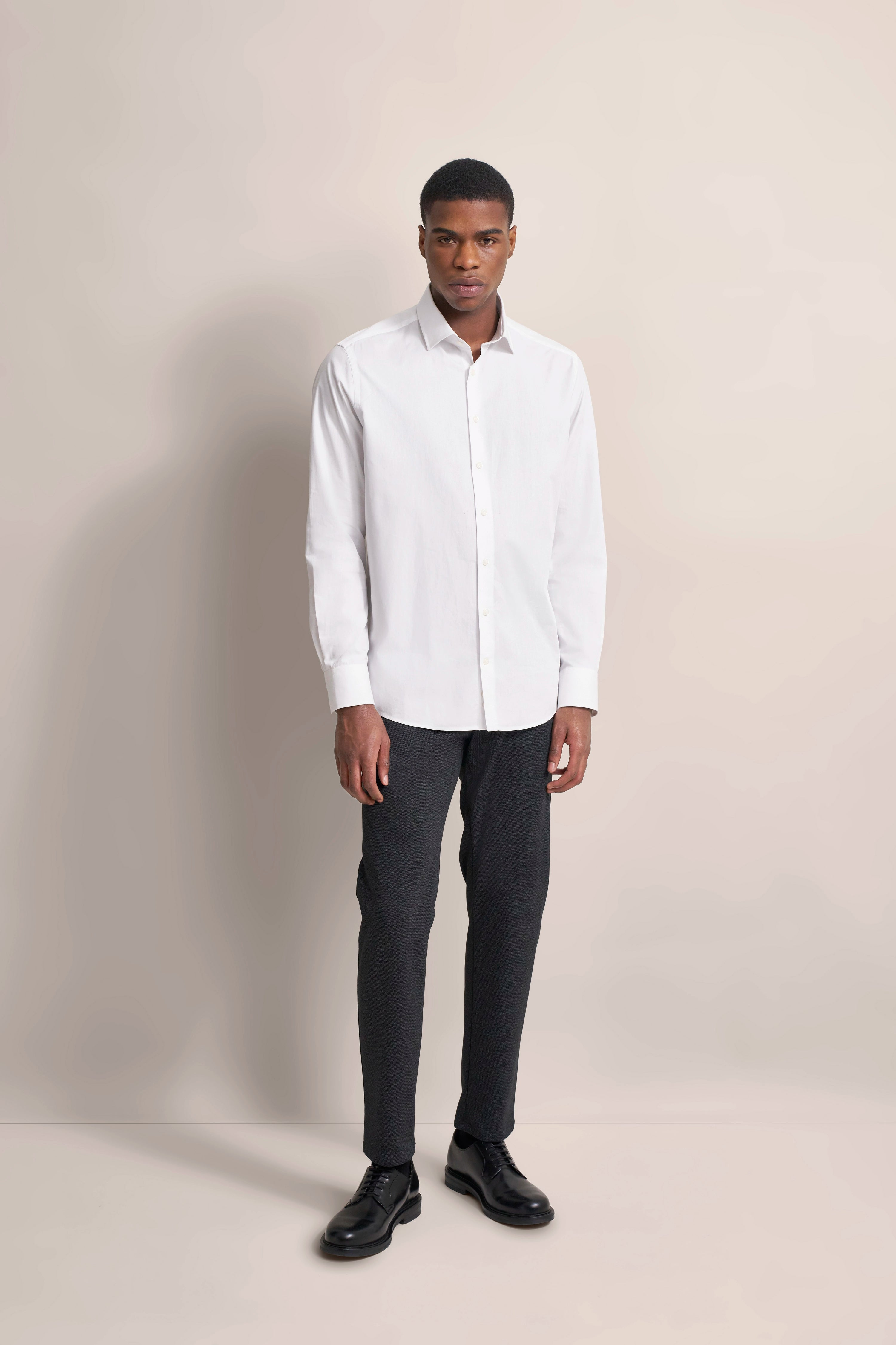 Weißes Hemd, graue Hose, schwarzer Schuh