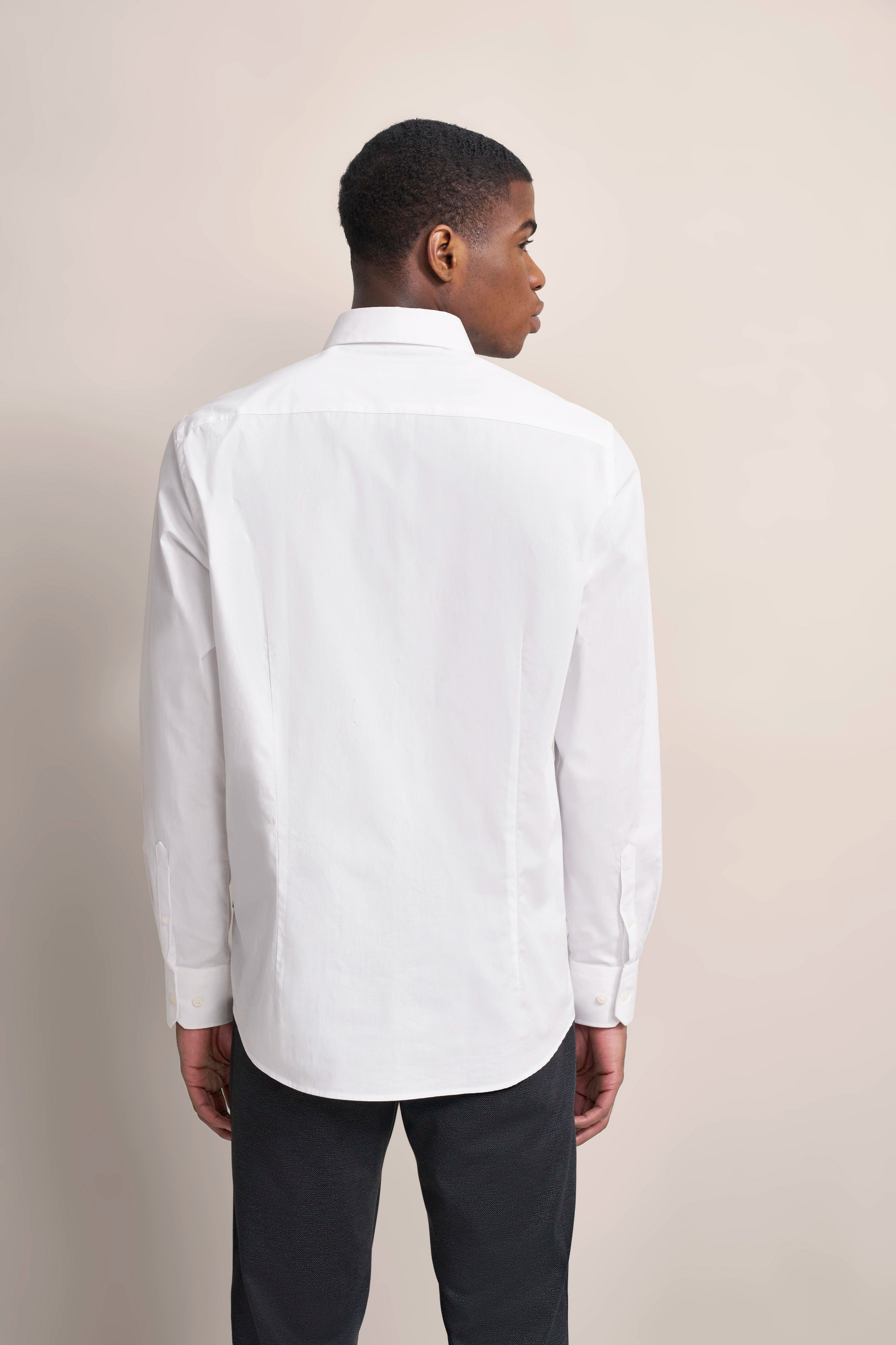 Weißes Hemd von bugatti, Model von hinten, schwarze Hose.