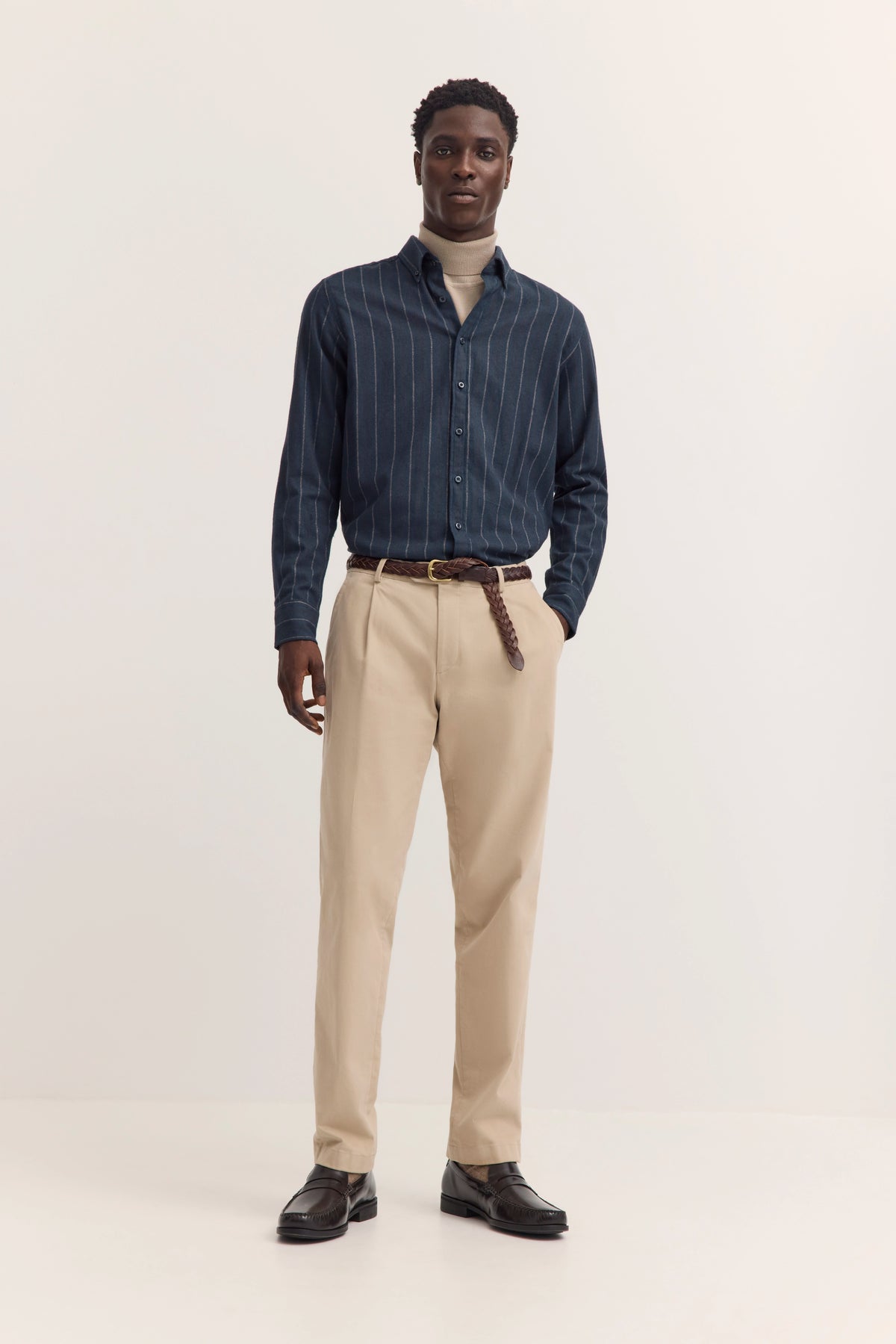 Model trägt navy gestreiftes Hemd, beige Hose