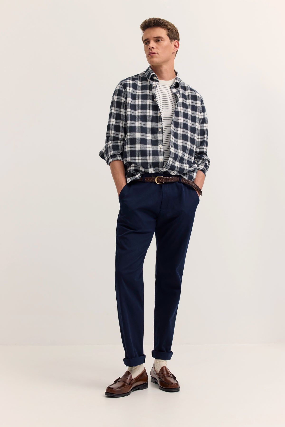 bugatti Modelbild: Kariertes Hemd, Streifen-Shirt, dunkelblaue Hose, braune Schuhe, lässige Pose.