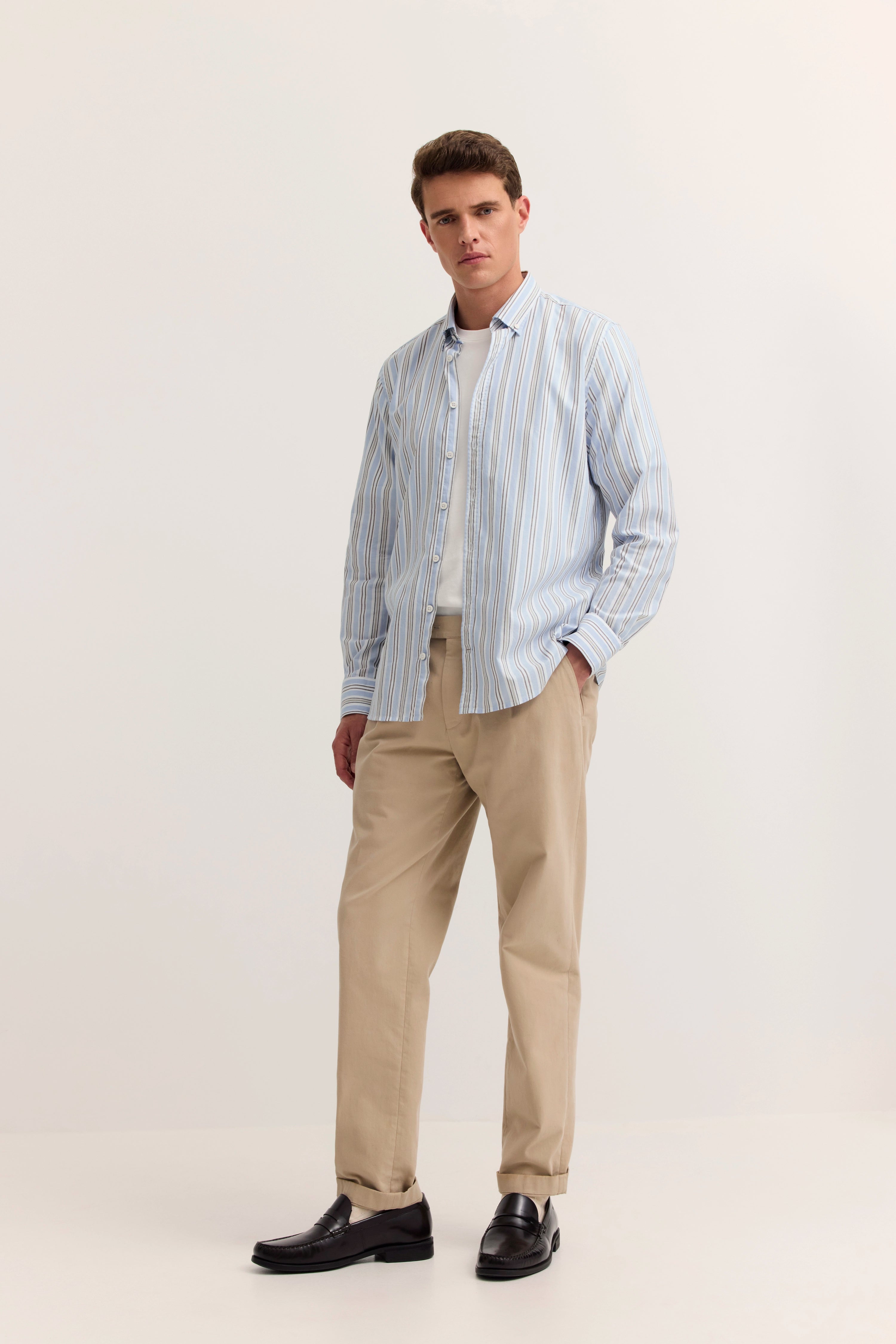 Model trägt gestreiftes bugatti-Hemd in Blau-Weiß, beige Chinos, schwarze Loafers