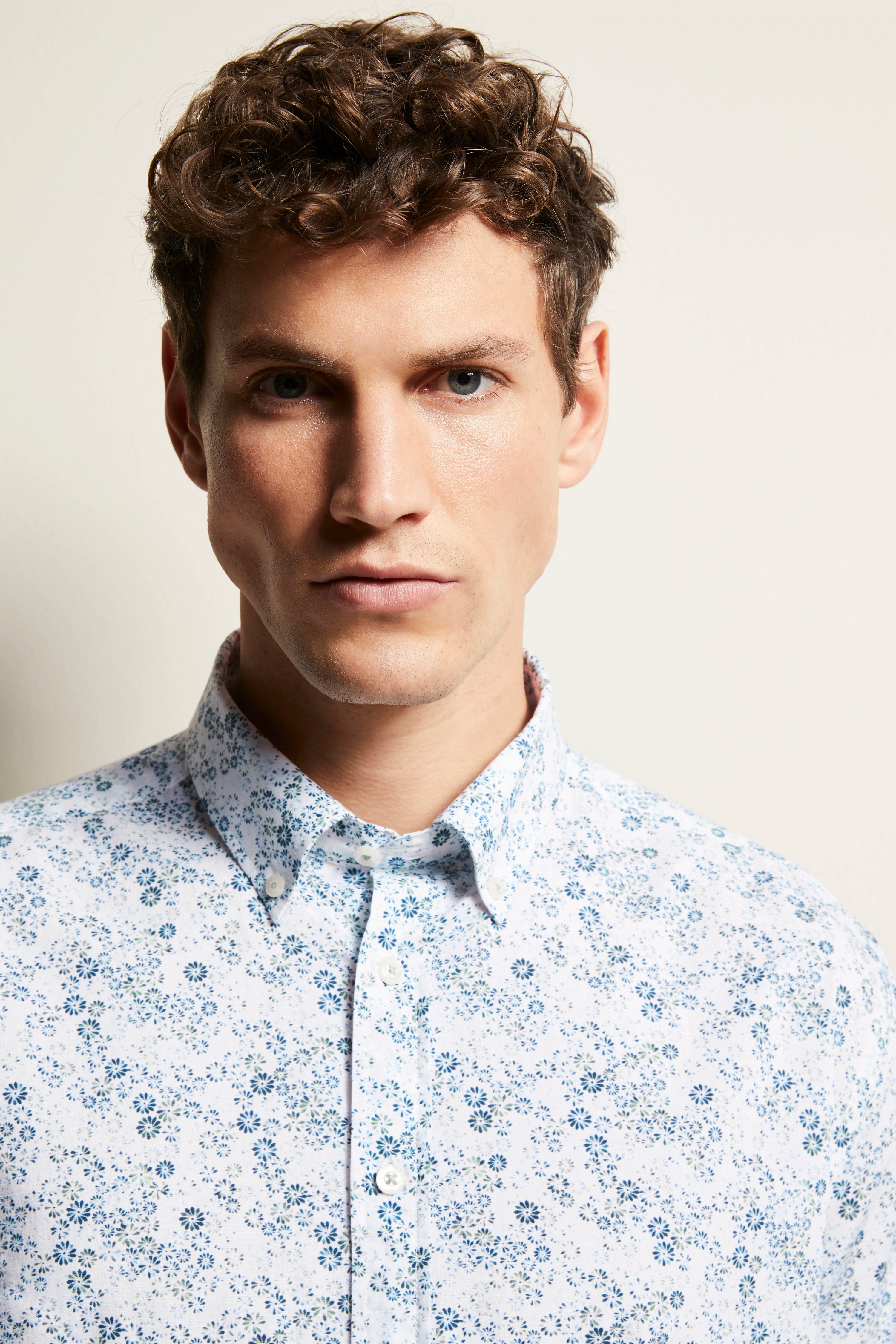 Bust of a man in a white shirt with blue floral pattern from bugatti.