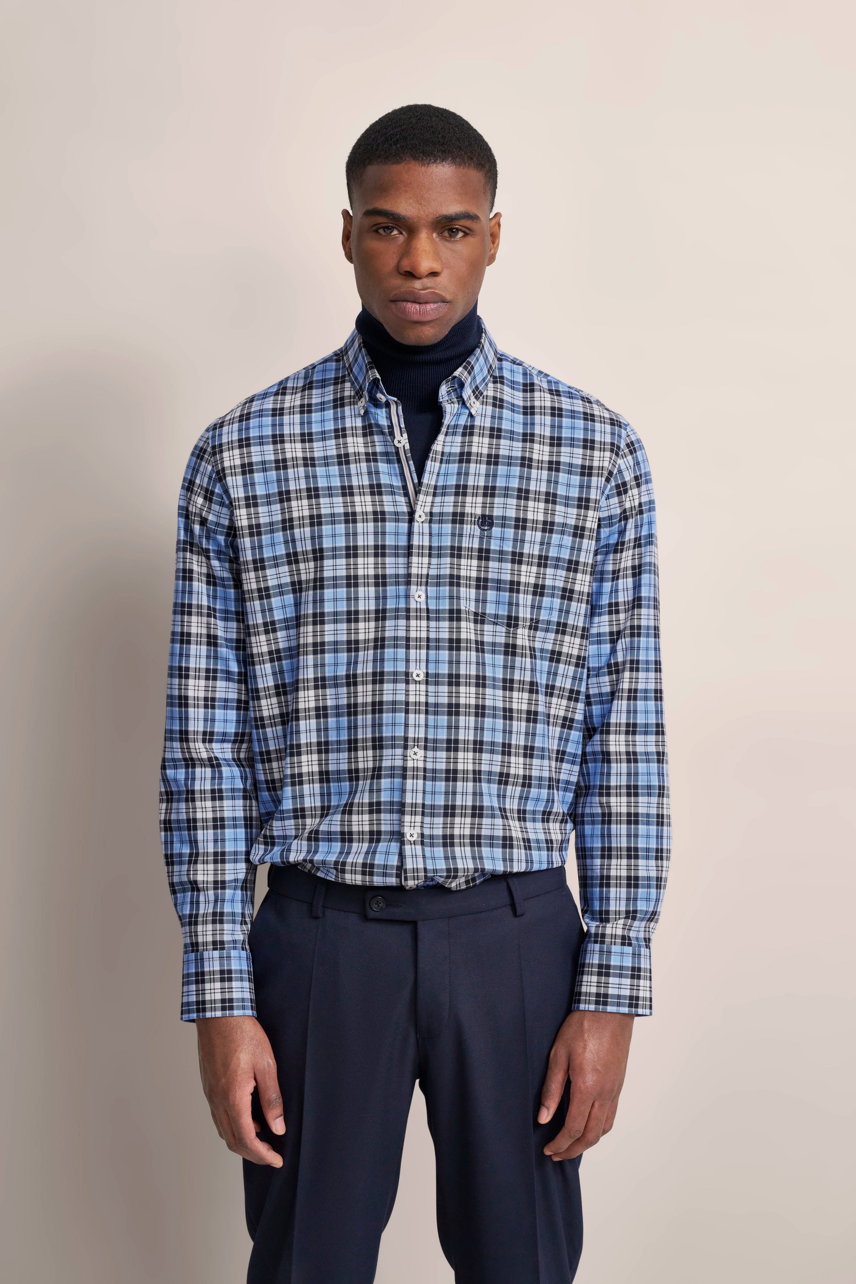 bugatti Modelbild: Mann in blau-schwarz kariertem Hemd und dunkelblauer Hose, frontal stehend.