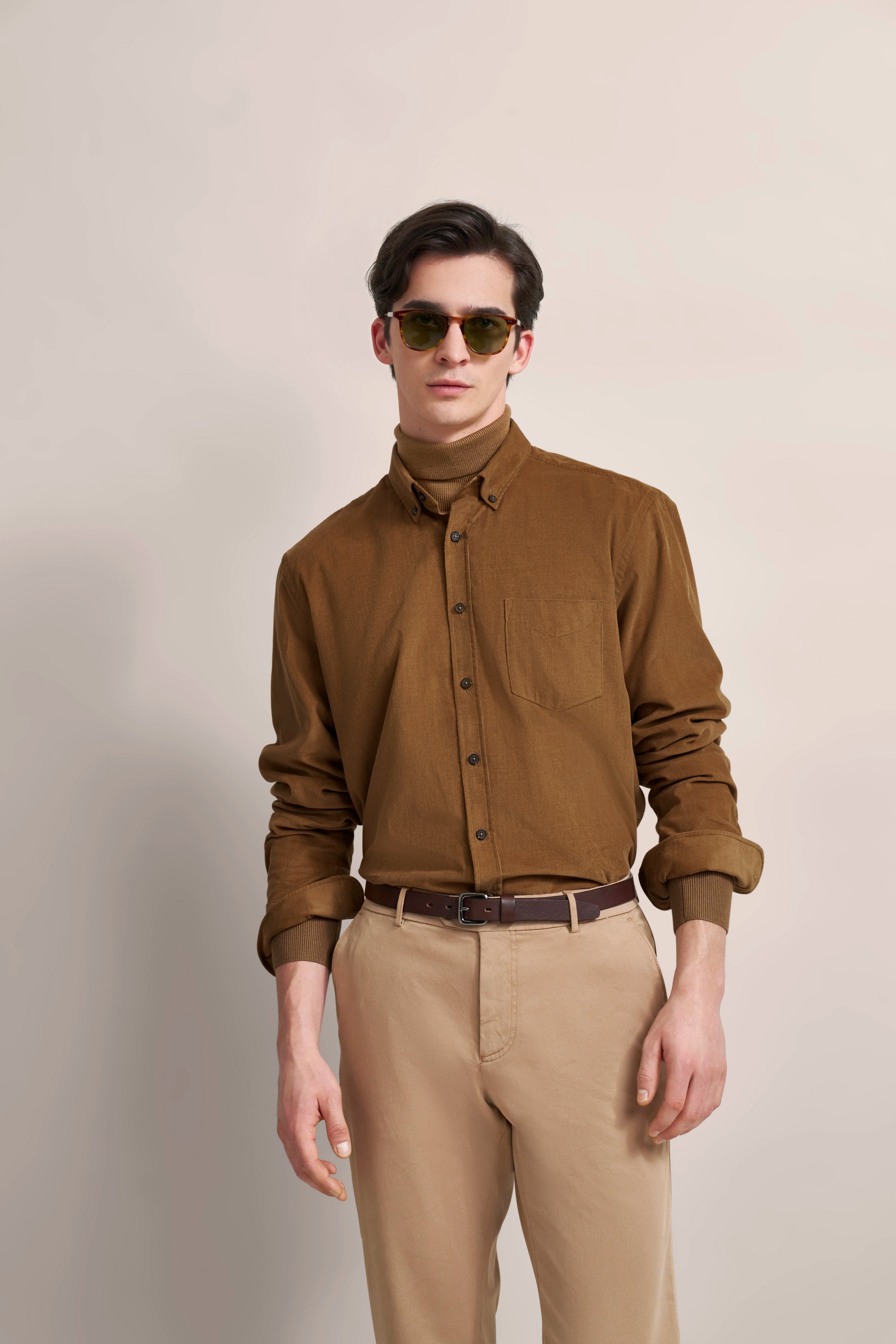 Model in braunem Hemd, beiger Hose, Sonnenbrille