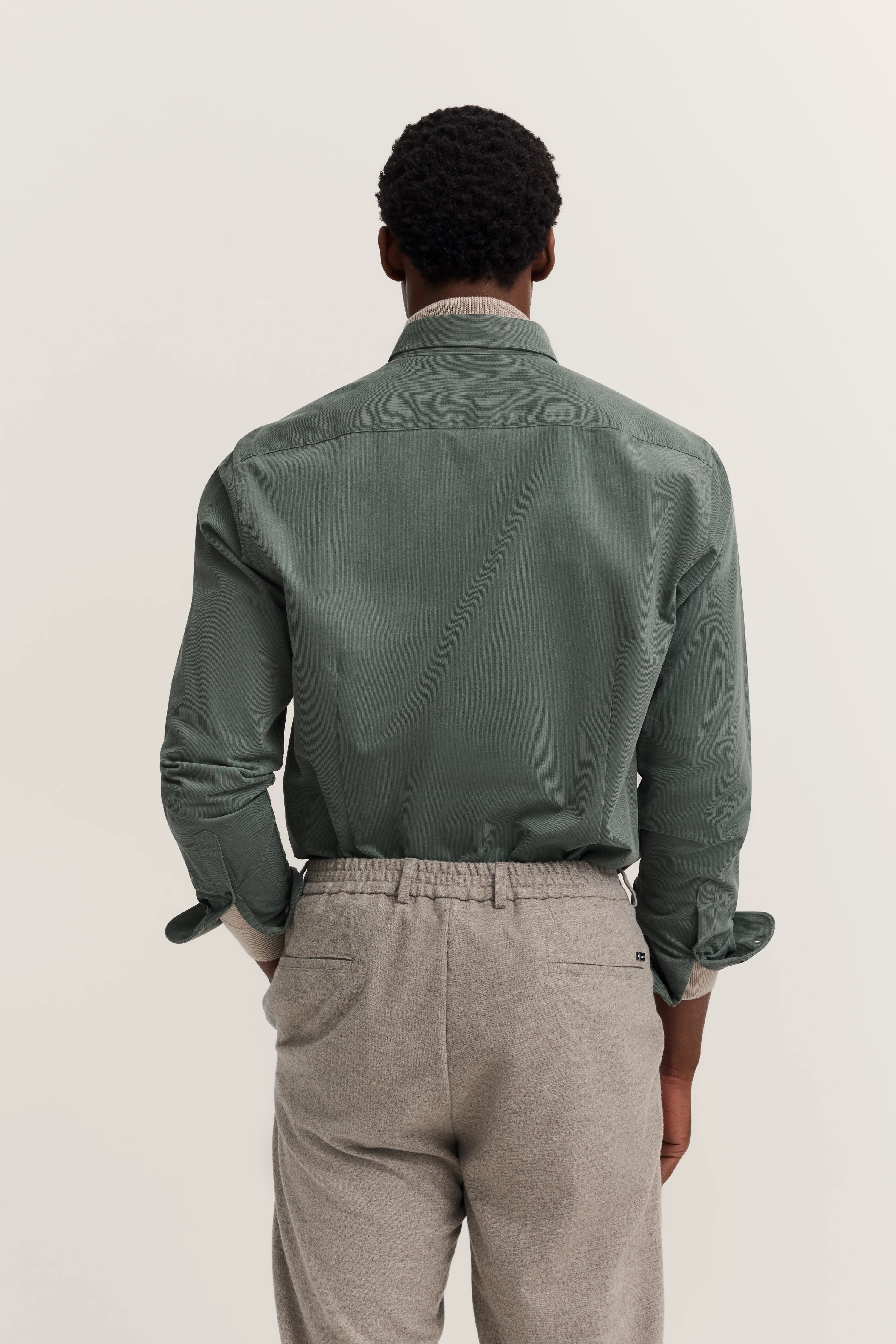 Groen bugatti overhemd en grijze broek, achteraanzicht, casual modelbeeld.