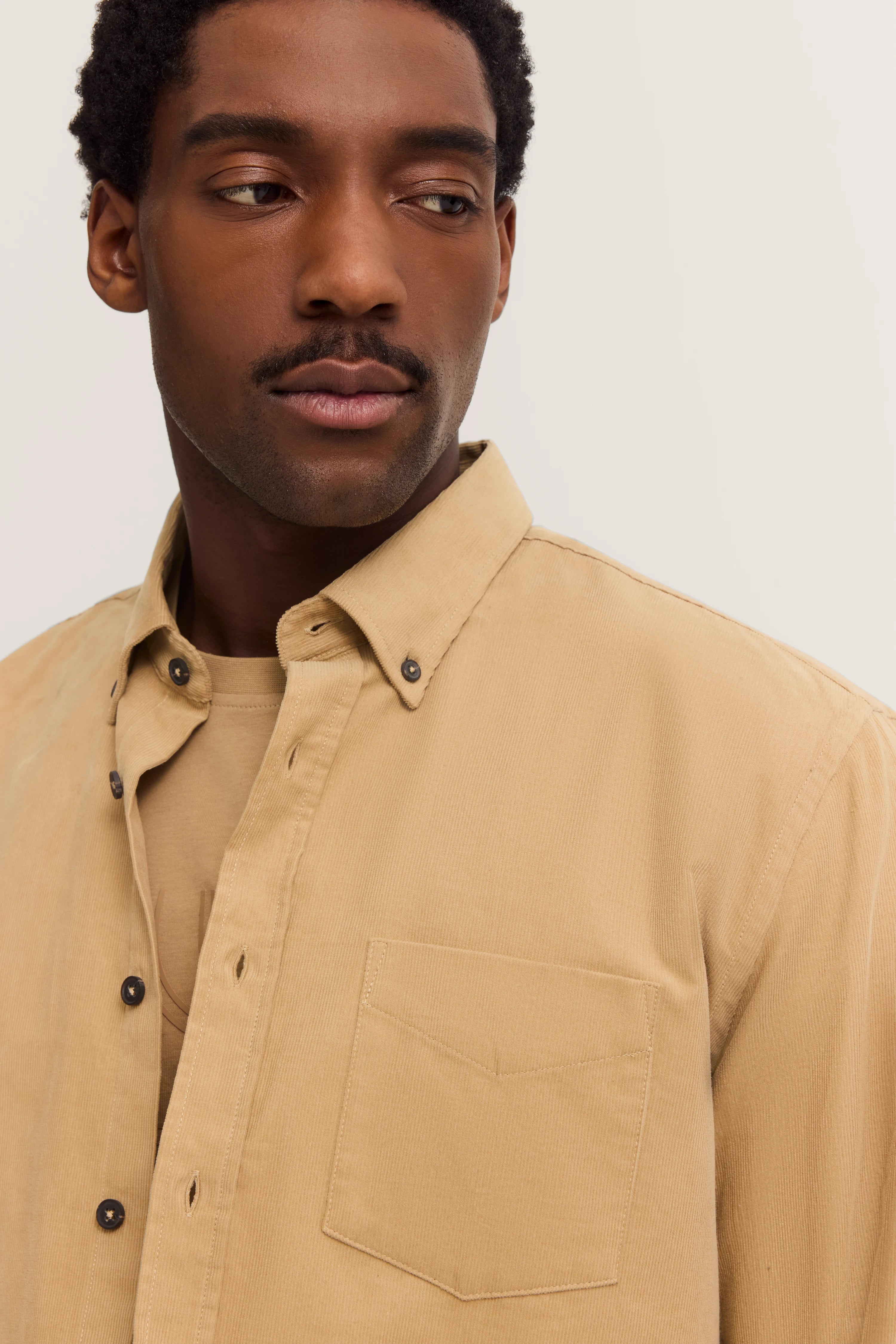 Beige bugatti overhemd, casual gedragen, model in ontspannen pose.