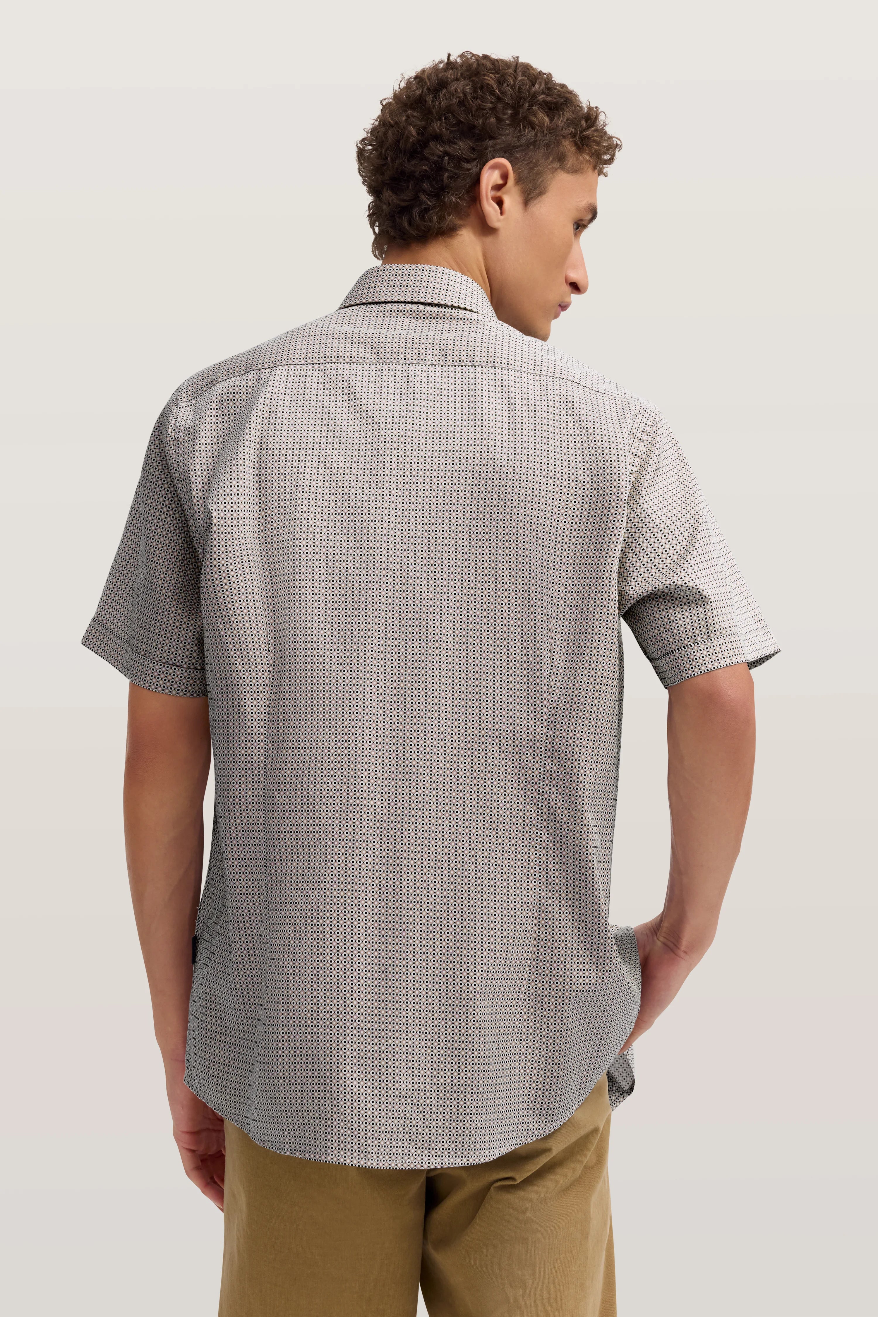 Kurzarm-Hemd mit feinem Muster in Grau, Rückansicht, lässig kombiniert mit beiger Hose, Model seitlich.
