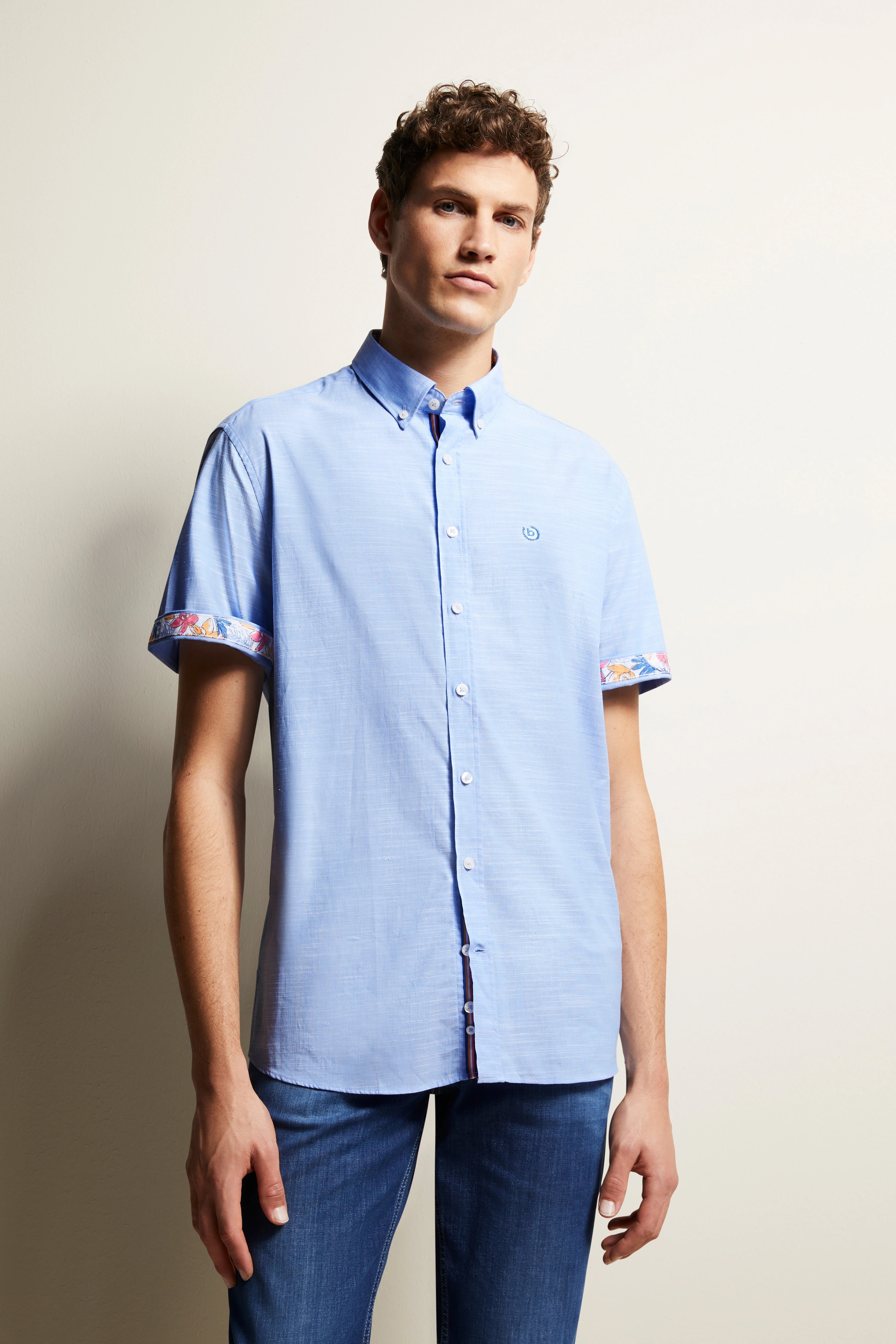 Blauw bugatti overhemd met contrastdetails, casual modelpose, ontspannen uitstraling.