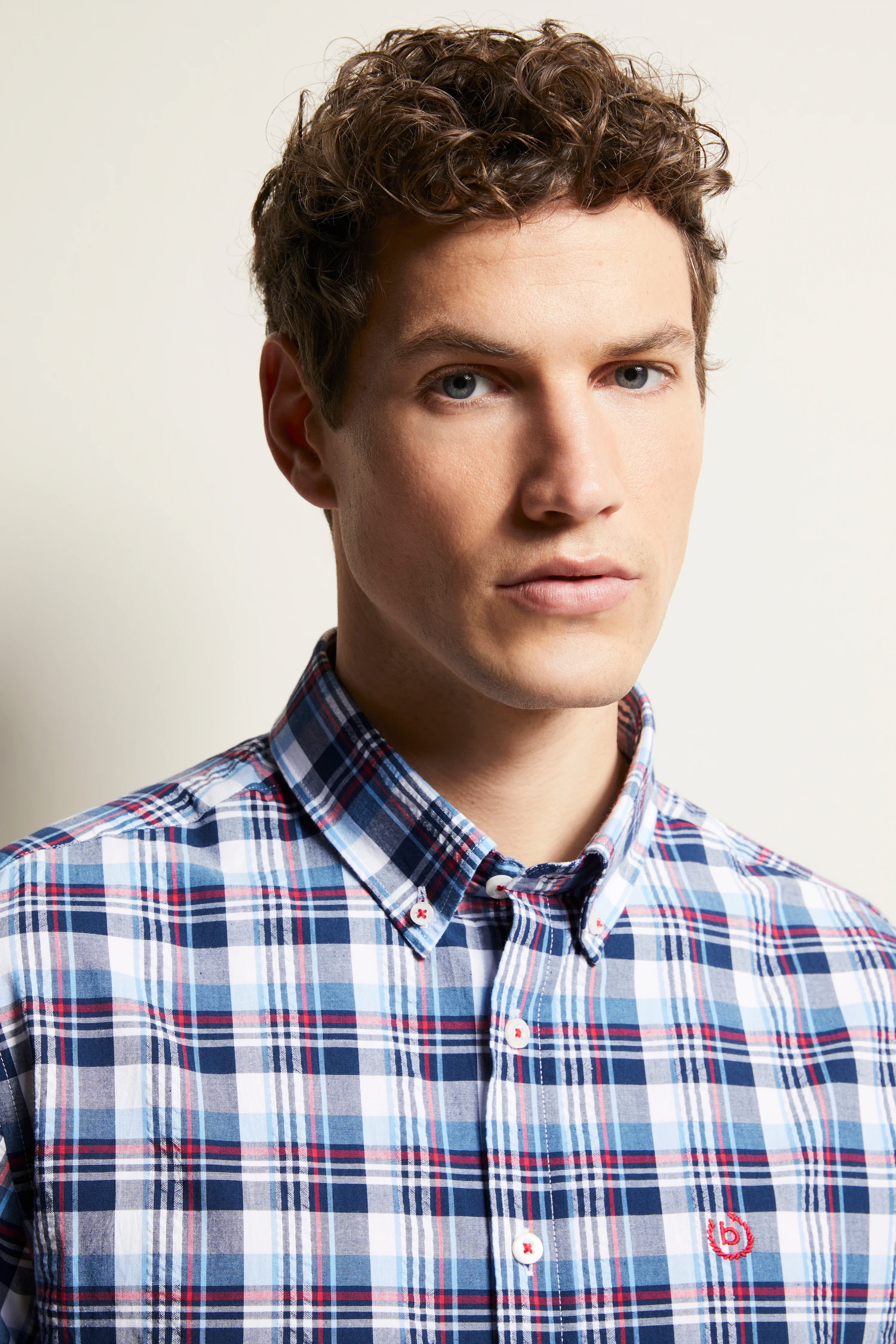 bugatti overhemd, blauw-wit-rood ruitjespatroon, model poseert ontspannen.
