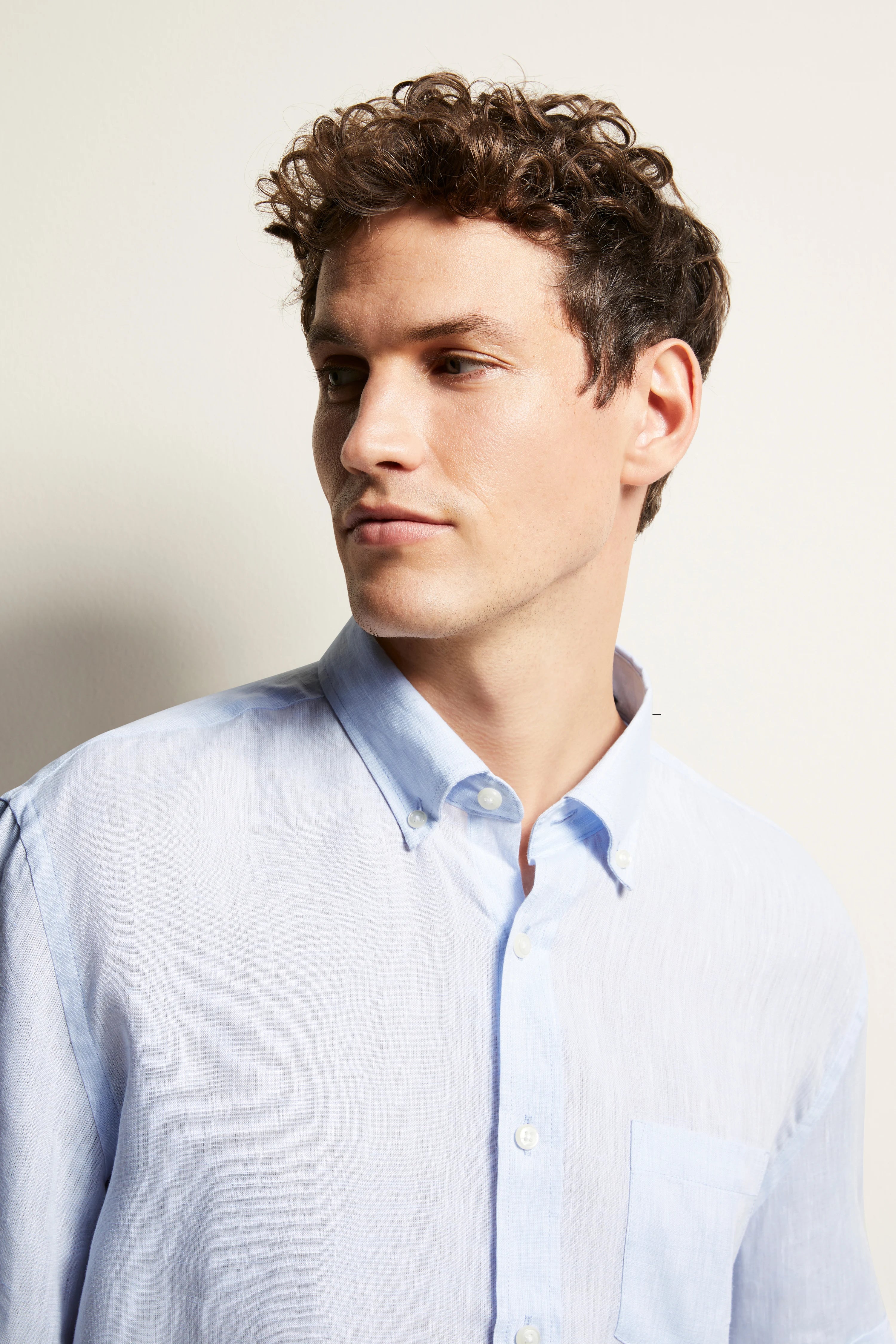 Model in lichtblauw bugatti overhemd met knoopsluiting en button-down kraag.