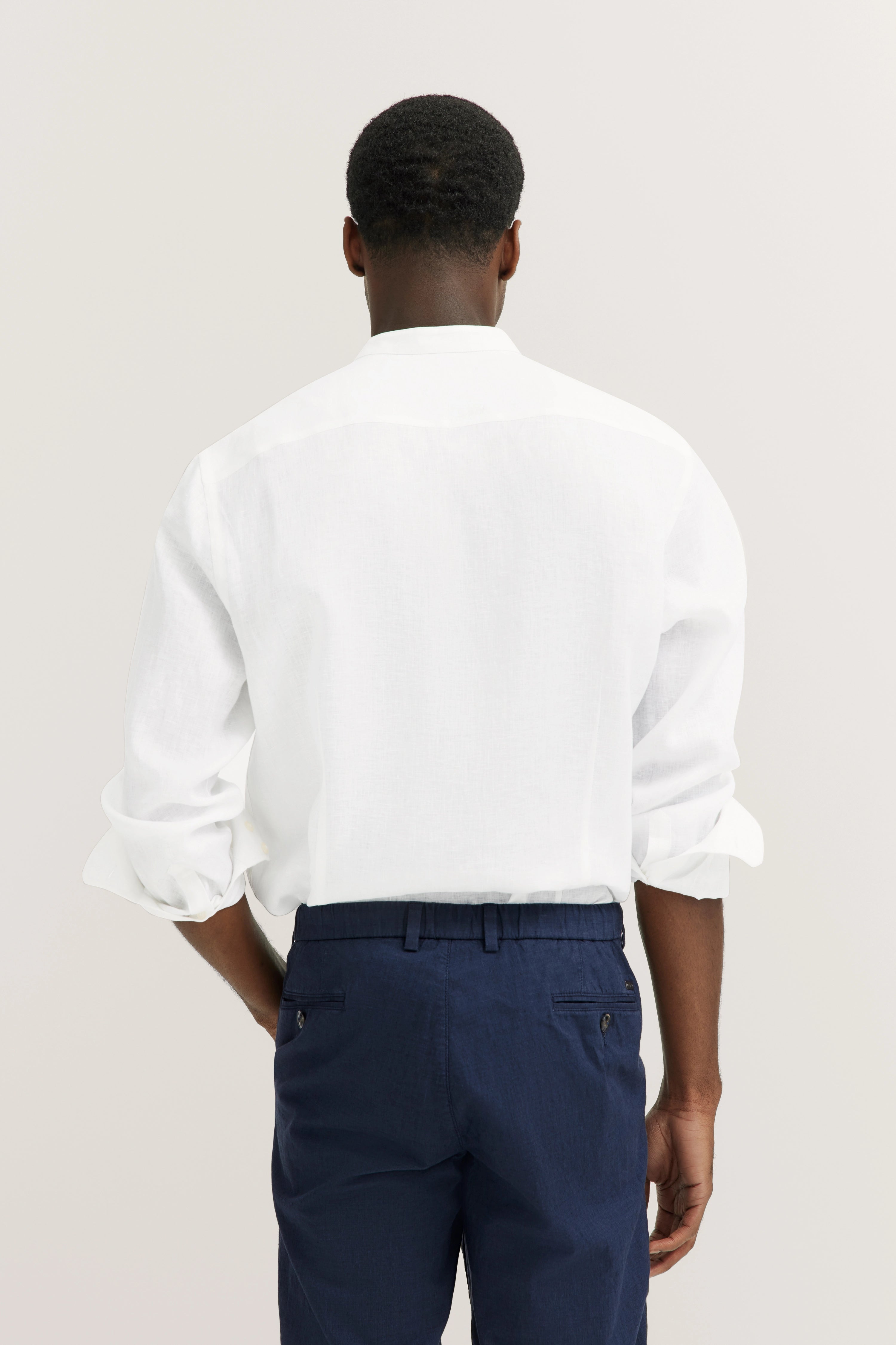 Witte bugatti overhemd achterkant met blauwe broek, casual modelbeeld van achteren.