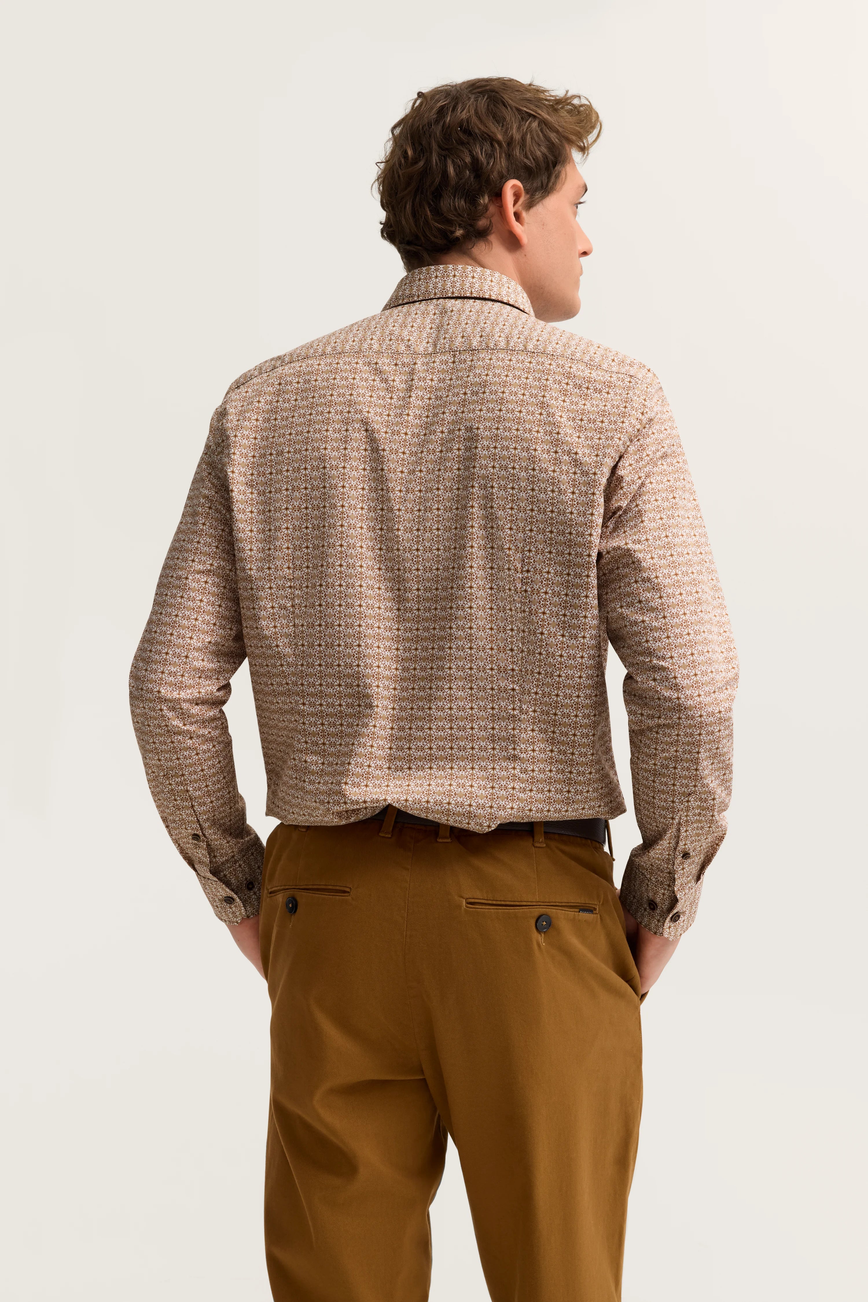 bugatti Model von hinten, Hemd mit Muster in Beige-Braun, braune Chino. Lockeres Stehen.