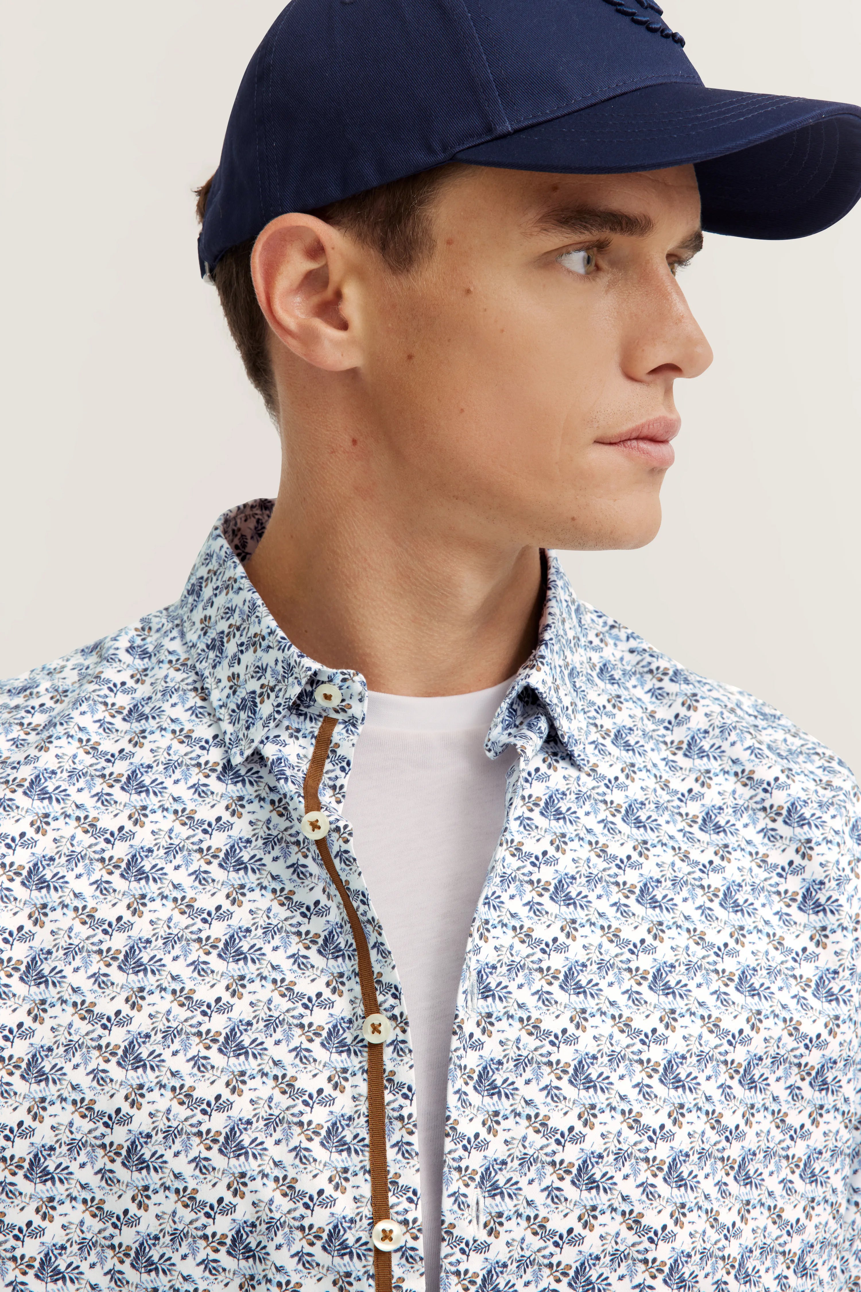 Model: Blau cap, blauw-wit gebloemd overhemd van bugatti.