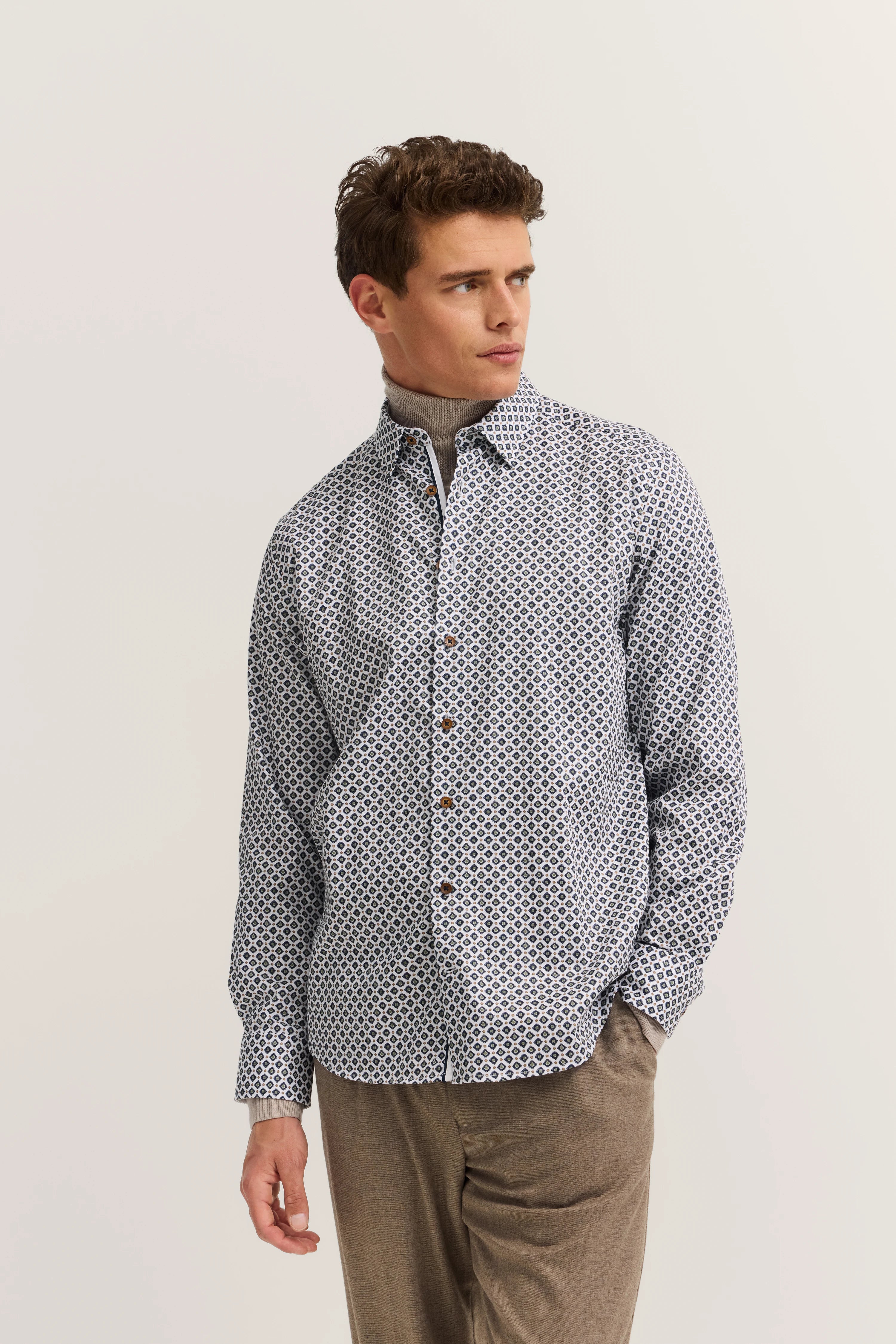 Model trägt gemustertes Hemd in Weiß/Blau, braune Hose