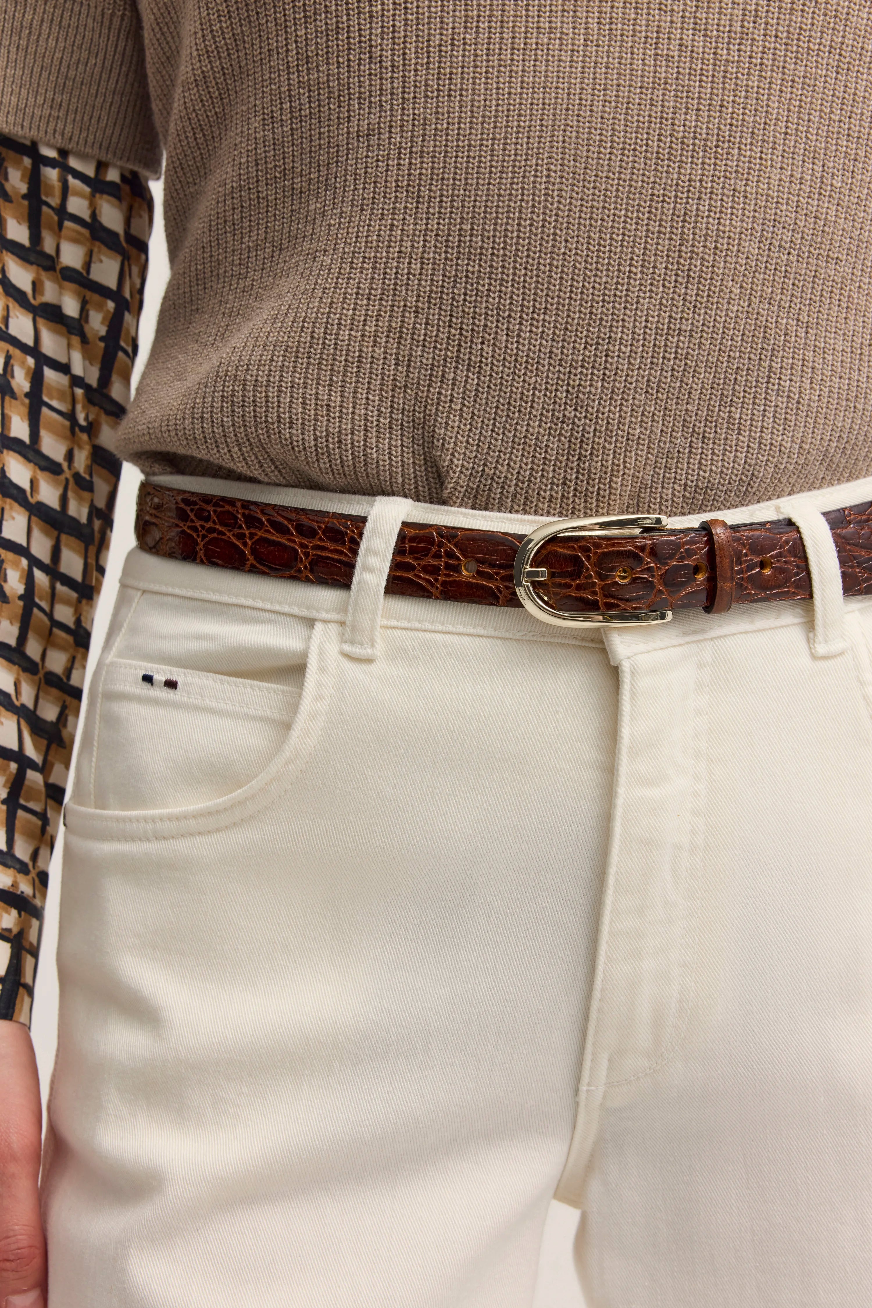 Beiger Pullover, weißer Hosenbund, brauner Gürtel mit Struktur, Detailaufnahme, bugatti Stil.