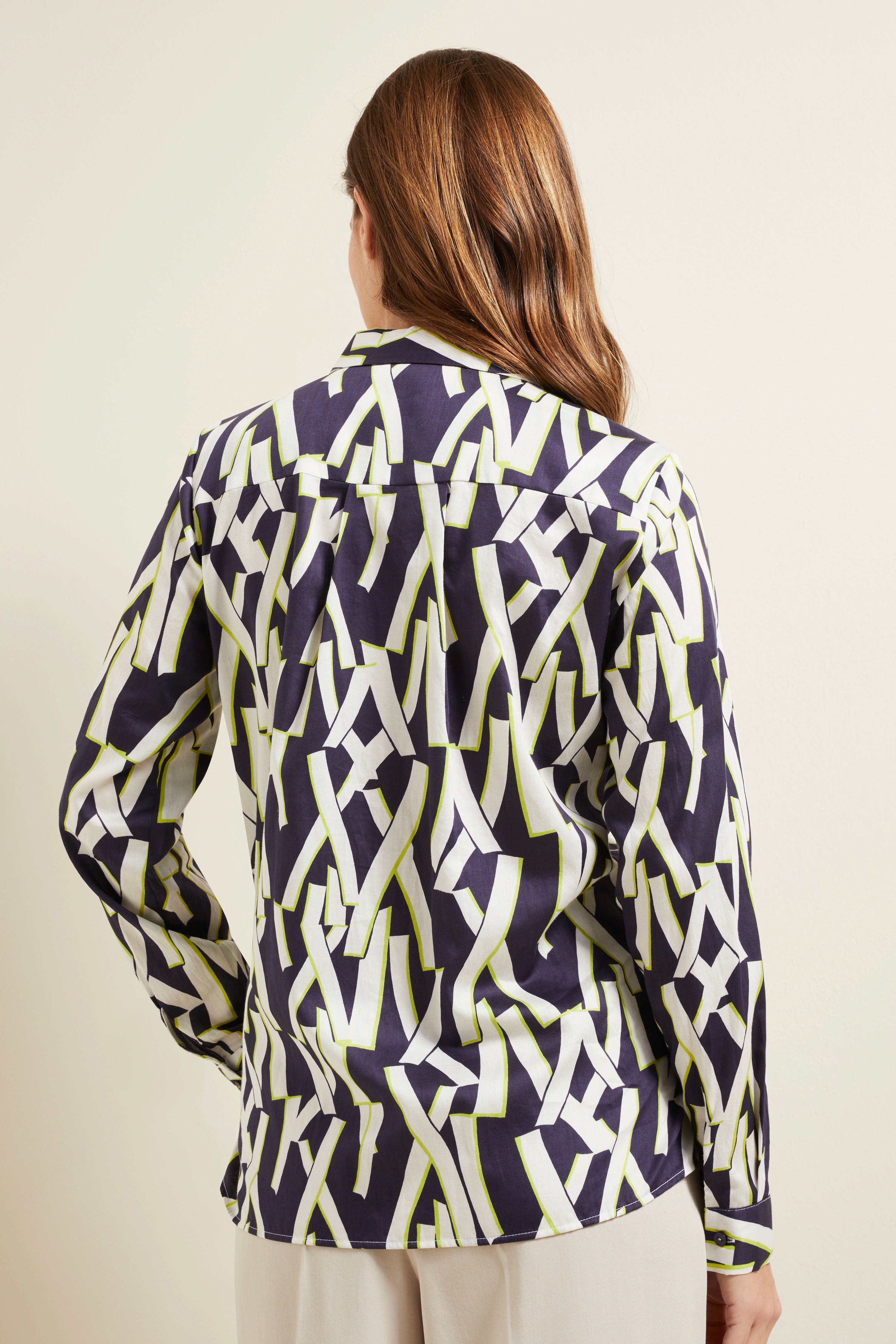 Bluse von bugatti mit abstraktem Muster in Dunkelblau, Weiß und Grün, Rückenansicht, legeres Modelbild.