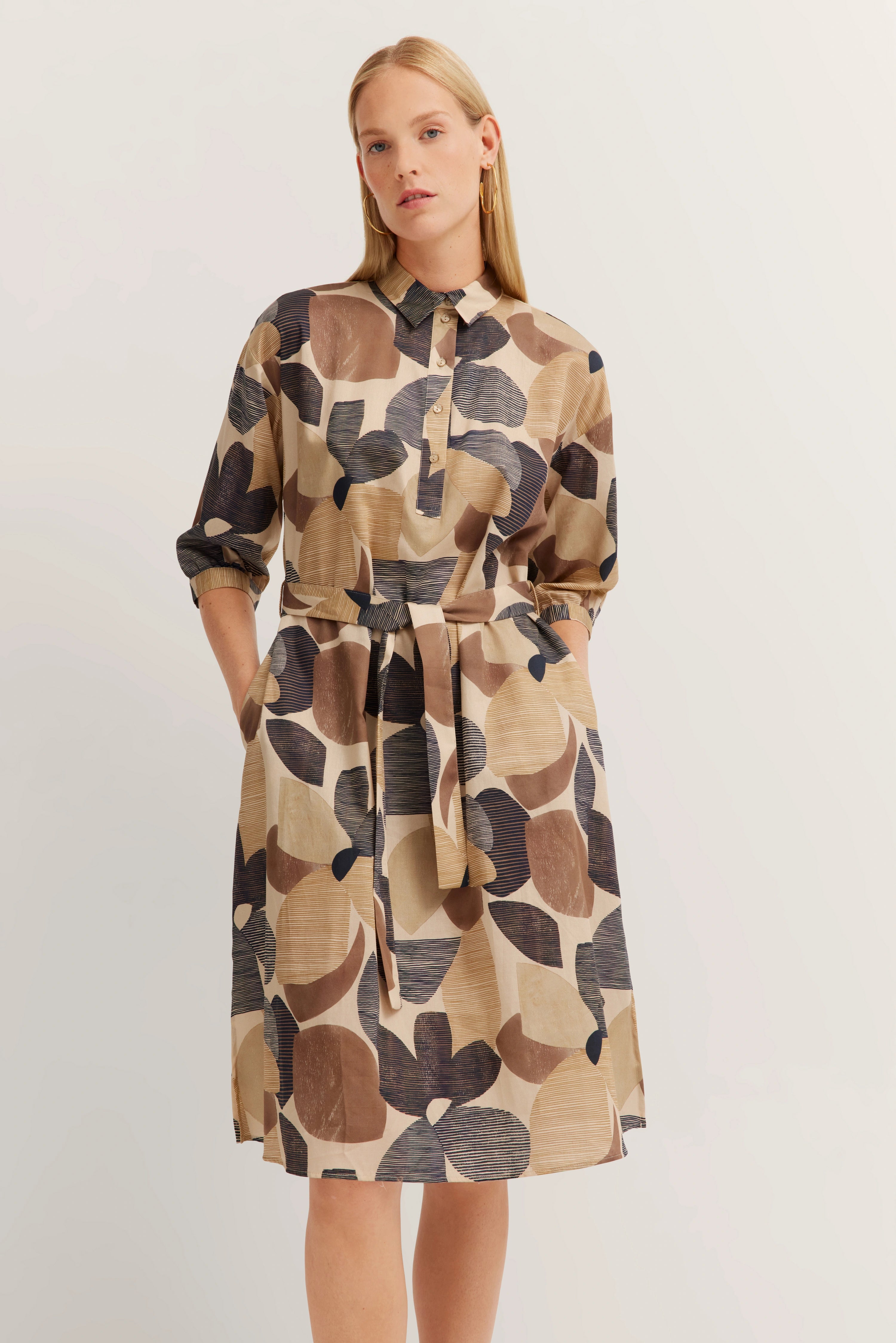 Model in gemustertem beige-braunem Kleid mit Gürtel, langärmlig, florales Design, bugatti Stil.