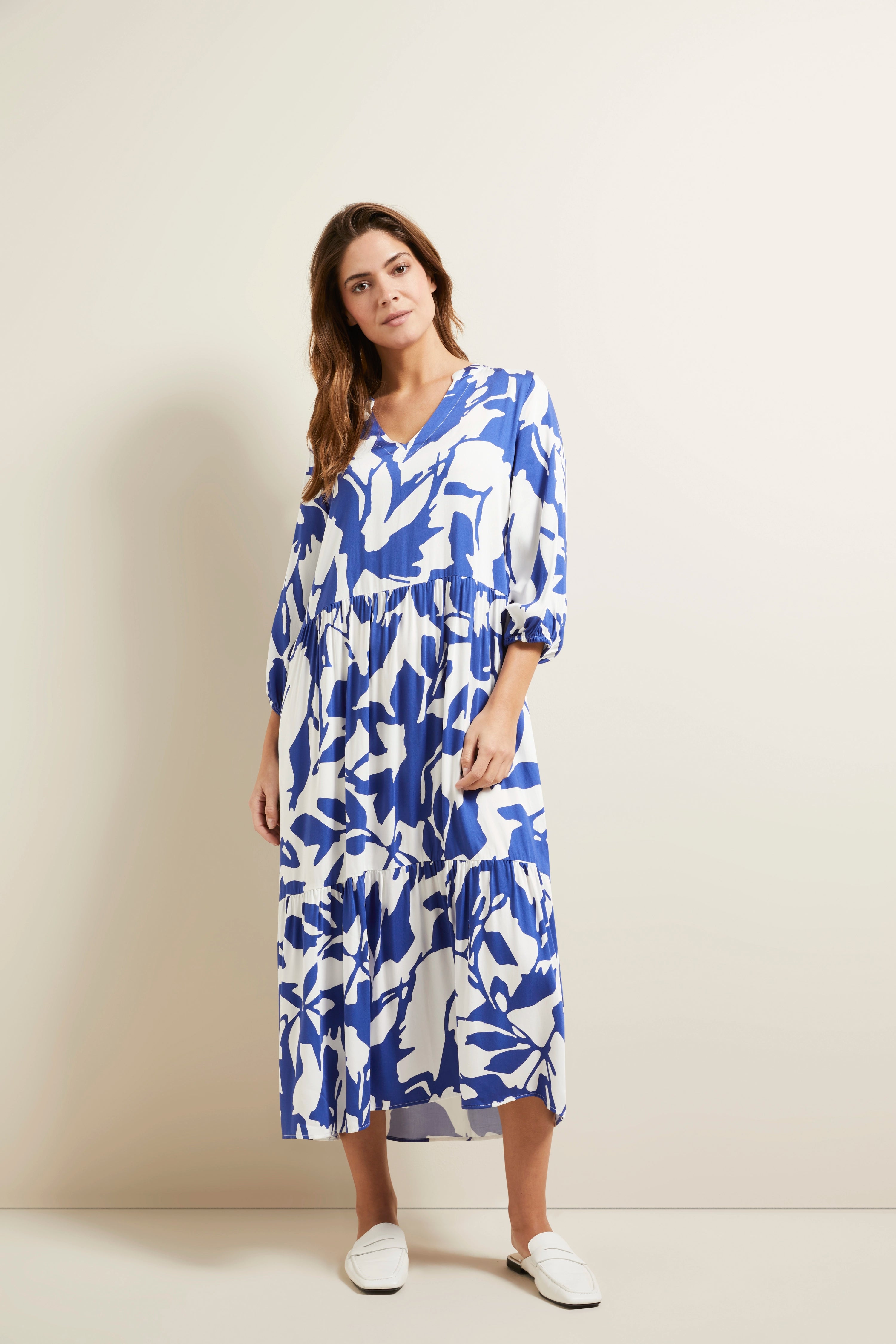 Model in blau-weiß geblümtem bugatti Kleid, legeres Posing, vermittelt Stil und Gelassenheit.