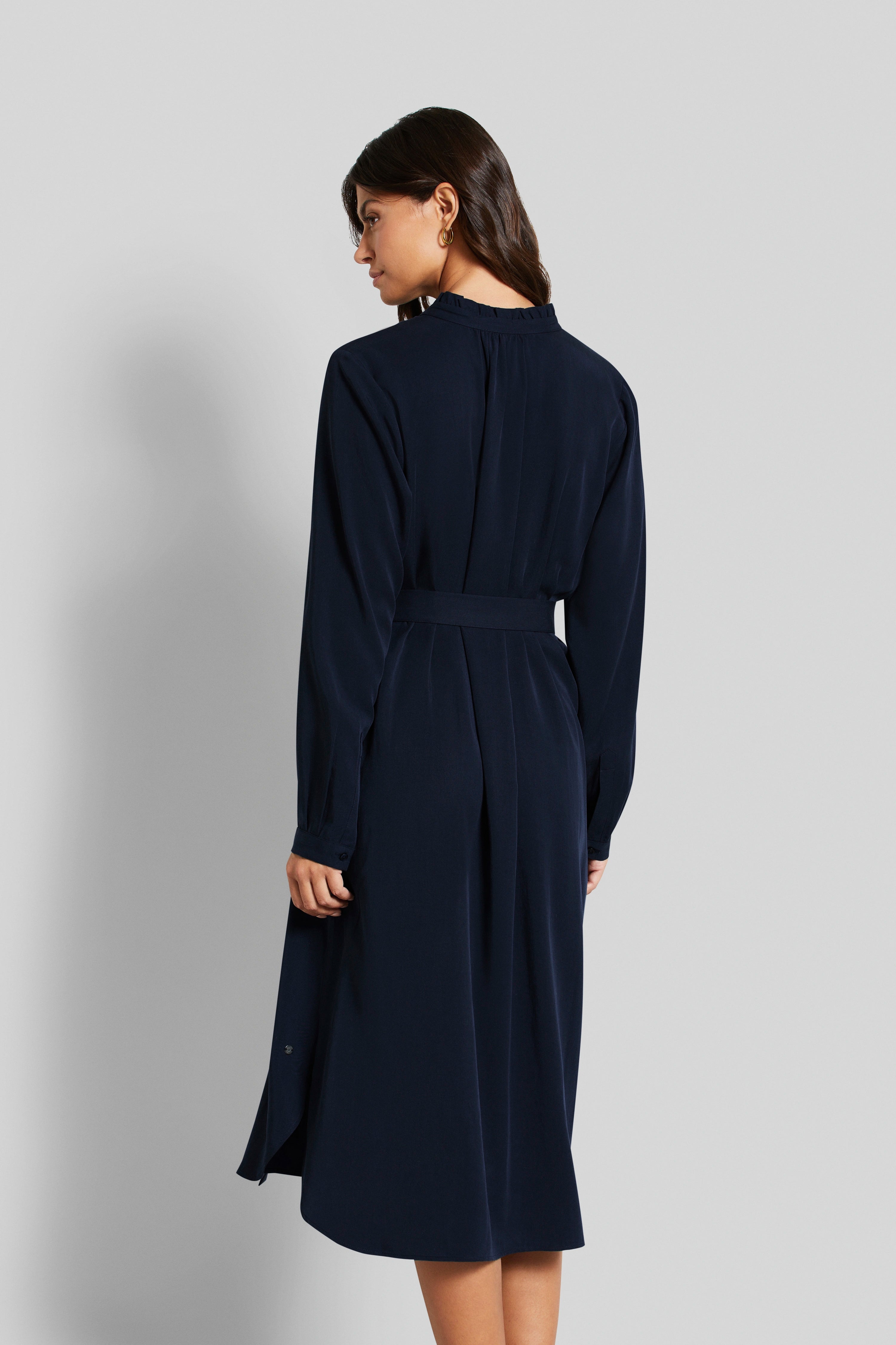 bugatti Modelbild, dunkelblaues Kleid, langer Ärmel, Rückansicht, entspannte Pose.
