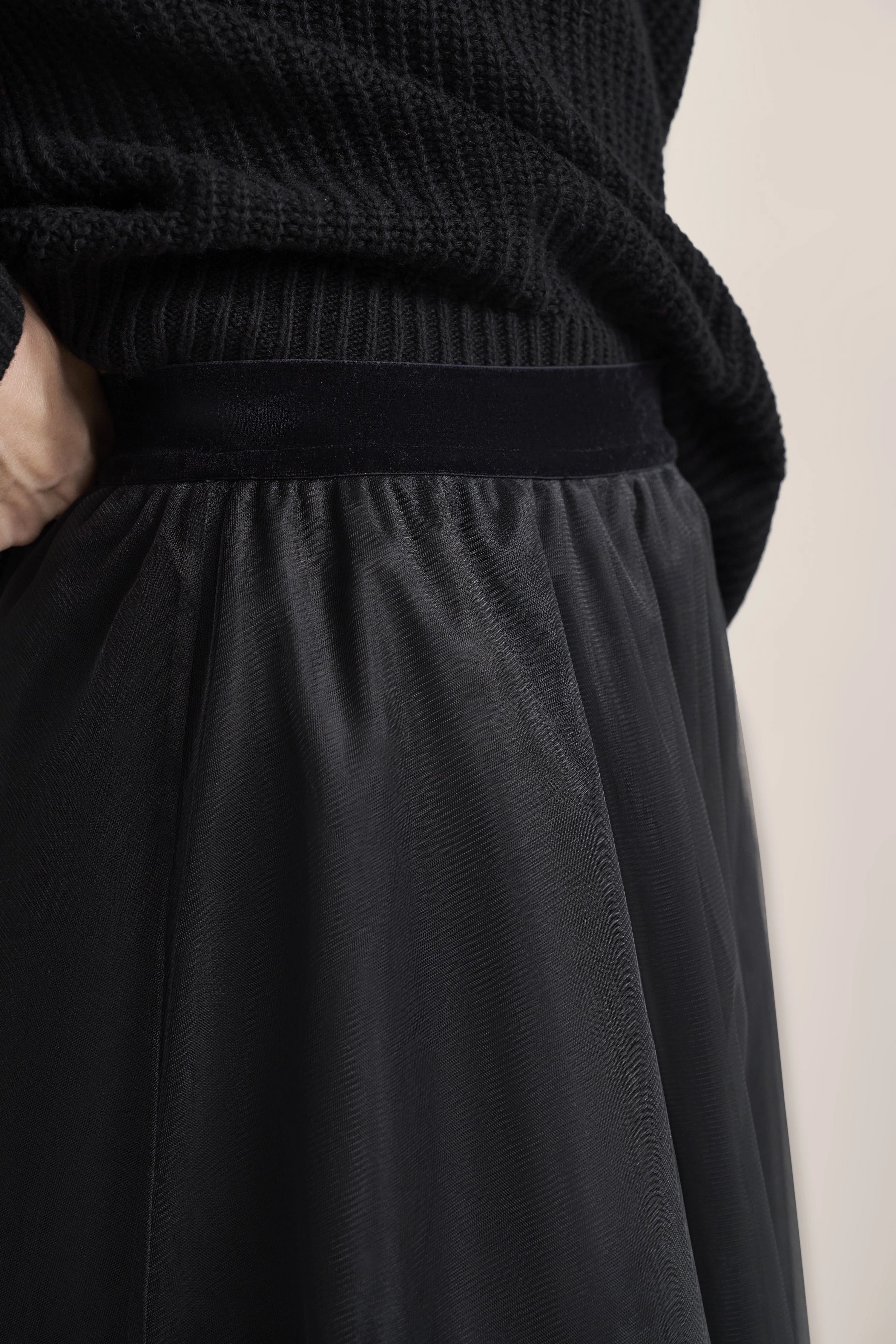 Schwarzer bugatti Strickpulli und Rock Detailaufnahme, legeres Büstenbild.