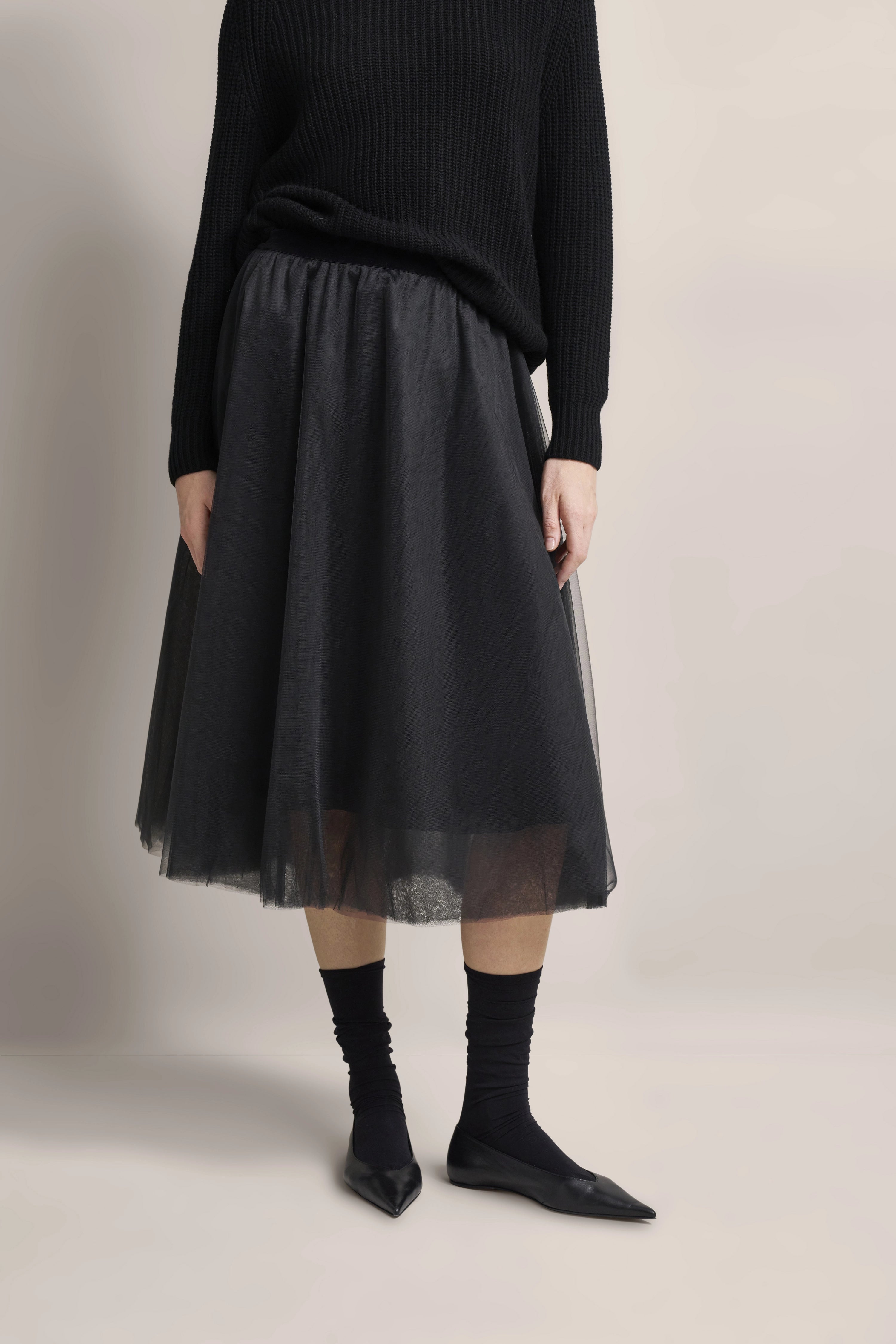 Schwarzer bugatti Pullover und Tüllrock, legeres Büstenbild, elegante, entspannte Ausstrahlung.