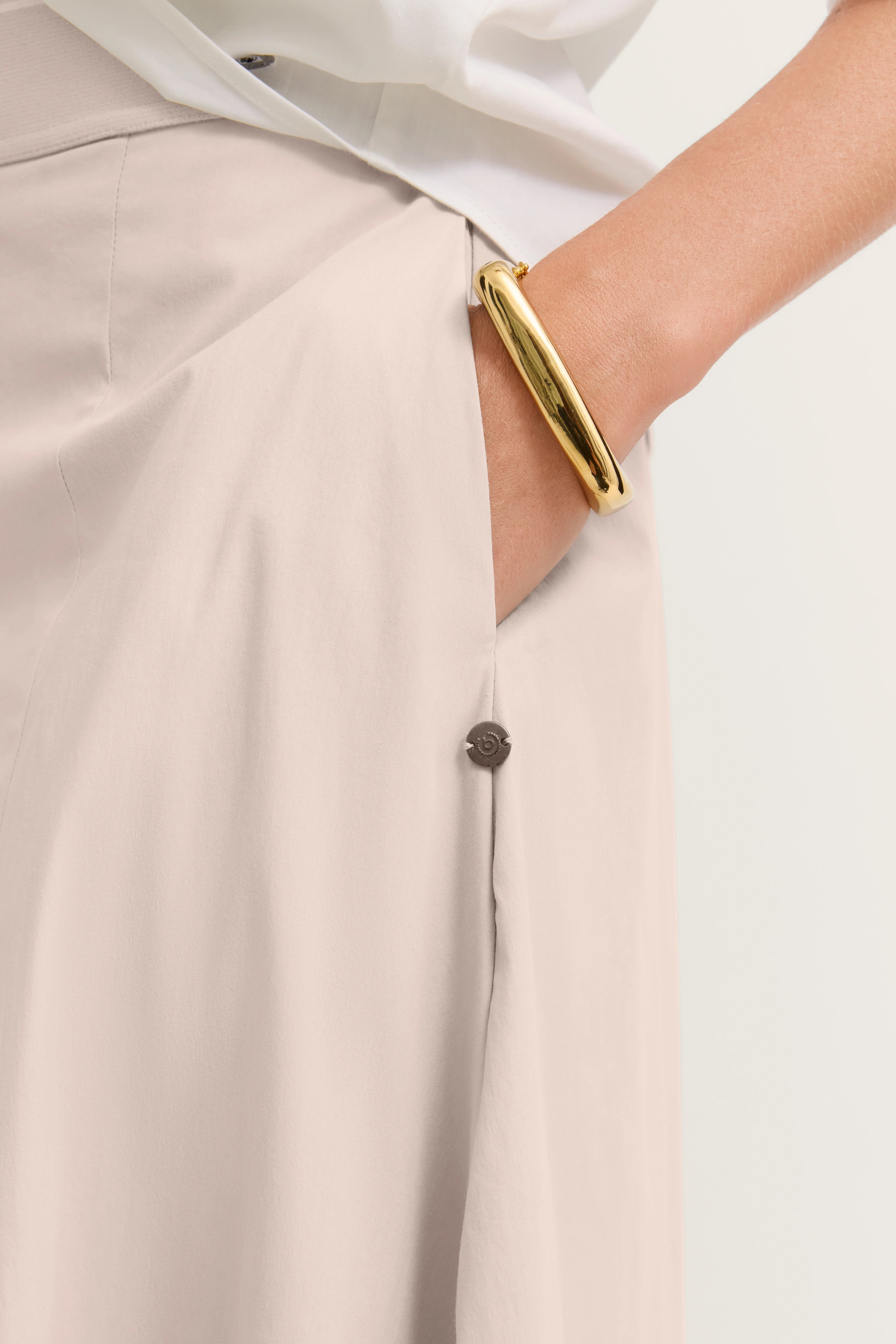 Beige bugatti-Rock mit goldener Armspange, legeres Outfit, detailreich und stilvoll.