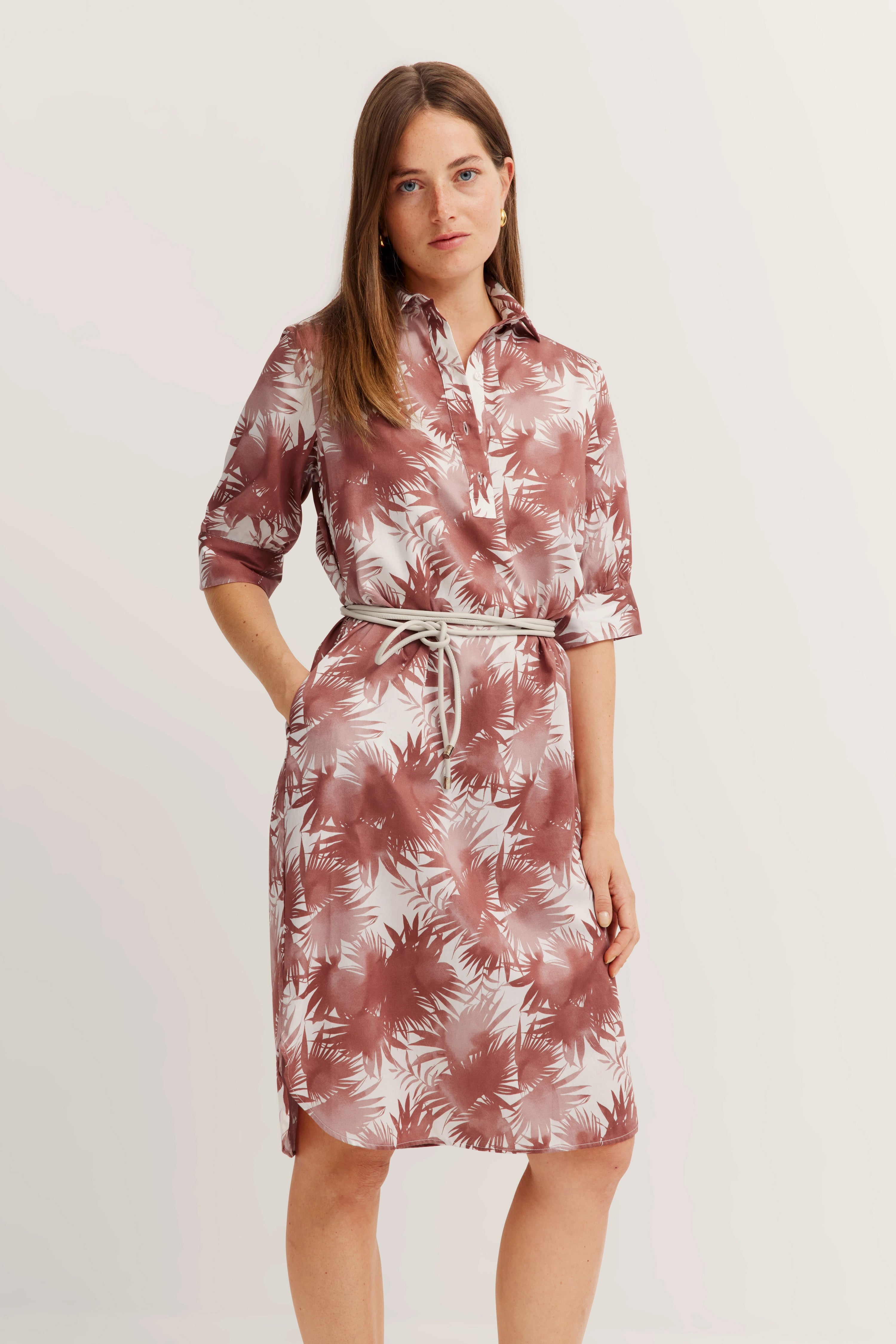 Model in bugatti shirt dress, red-white palm pattern, casual pose, hands in pockets.