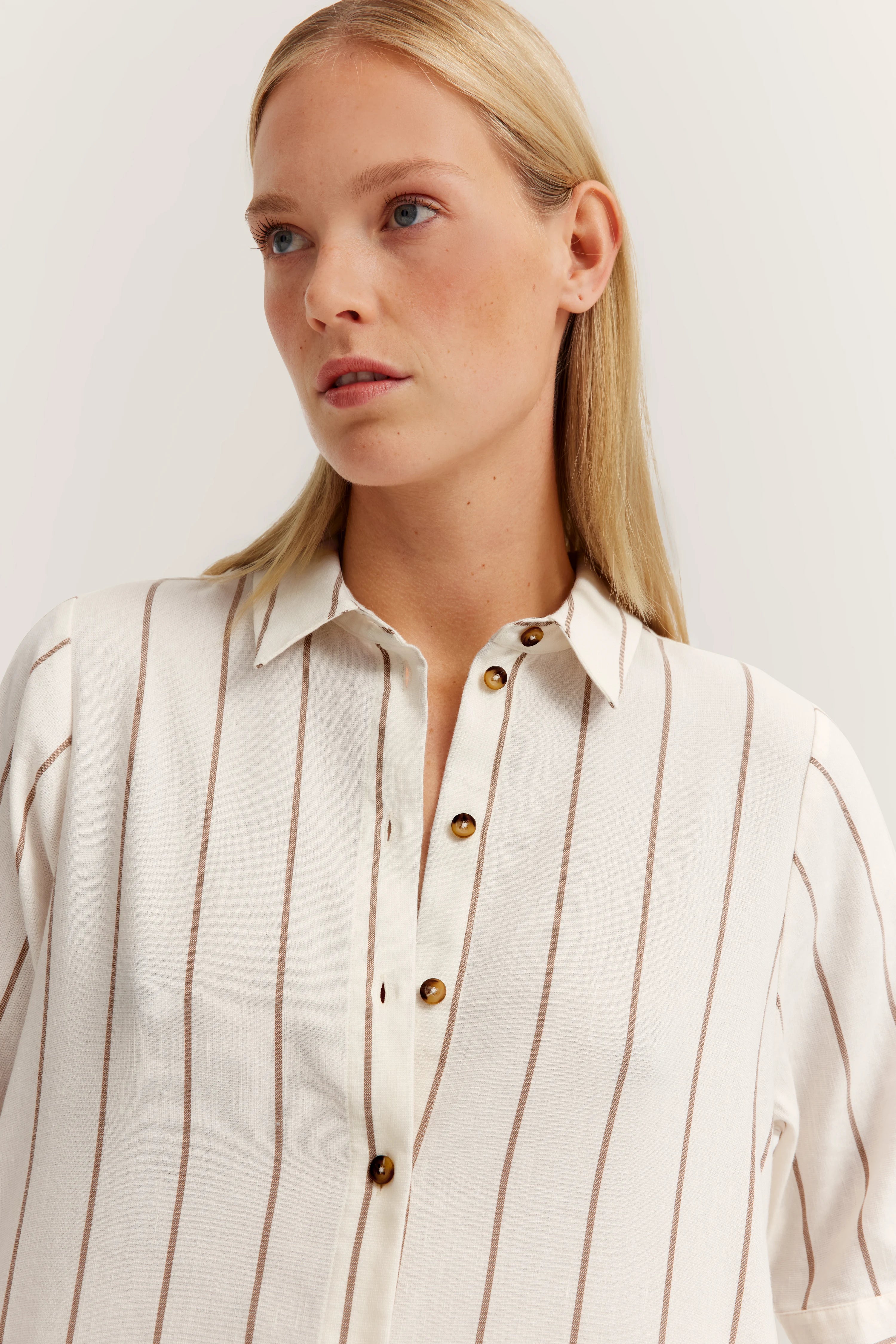 Cream blouse with brown stripes, bust image, bugatti style. Elegant, high-quality, and timeless.