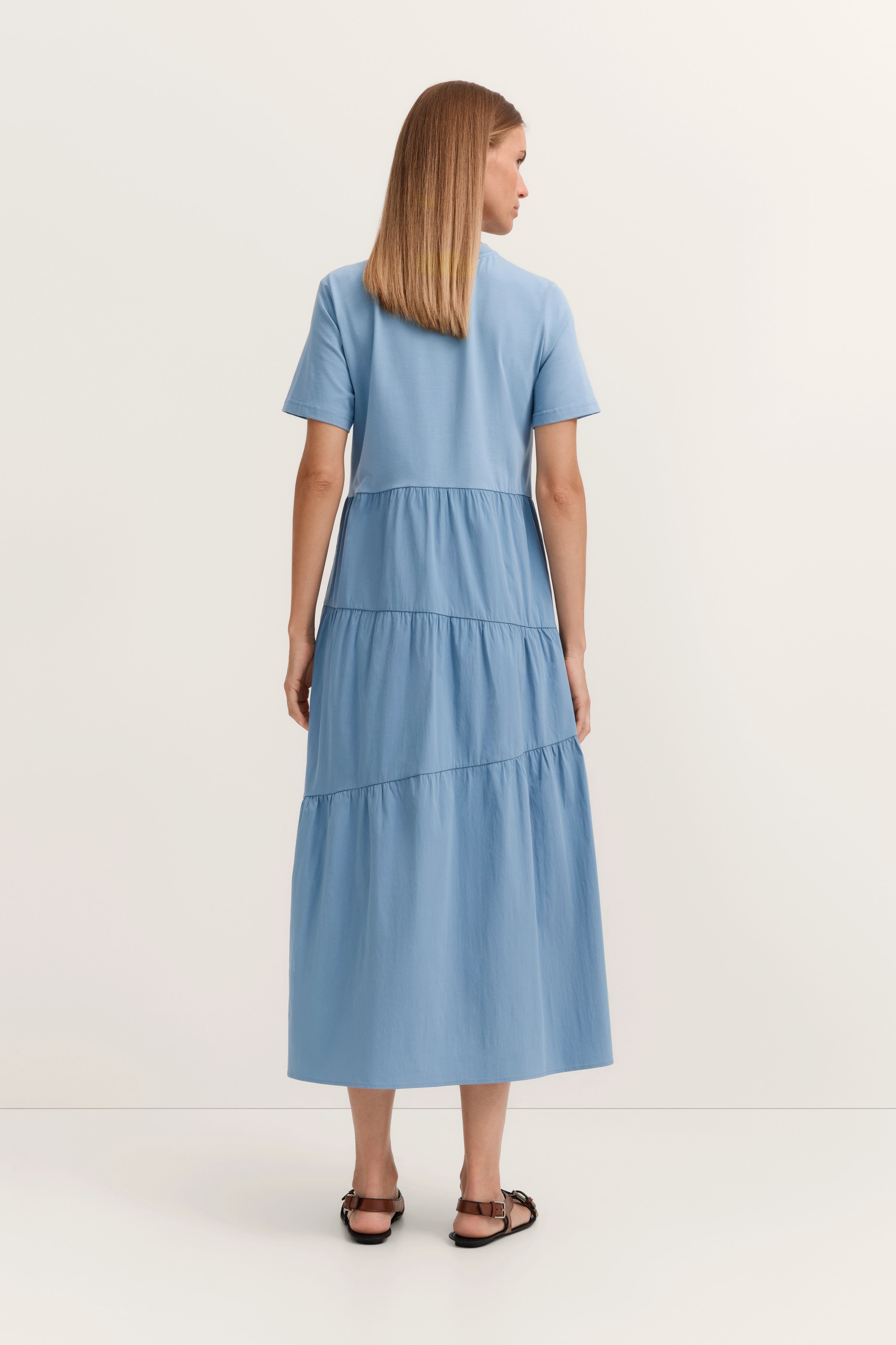 Blaues bugatti Maxikleid, Kurzarm, Model von hinten, entspannt stehend.