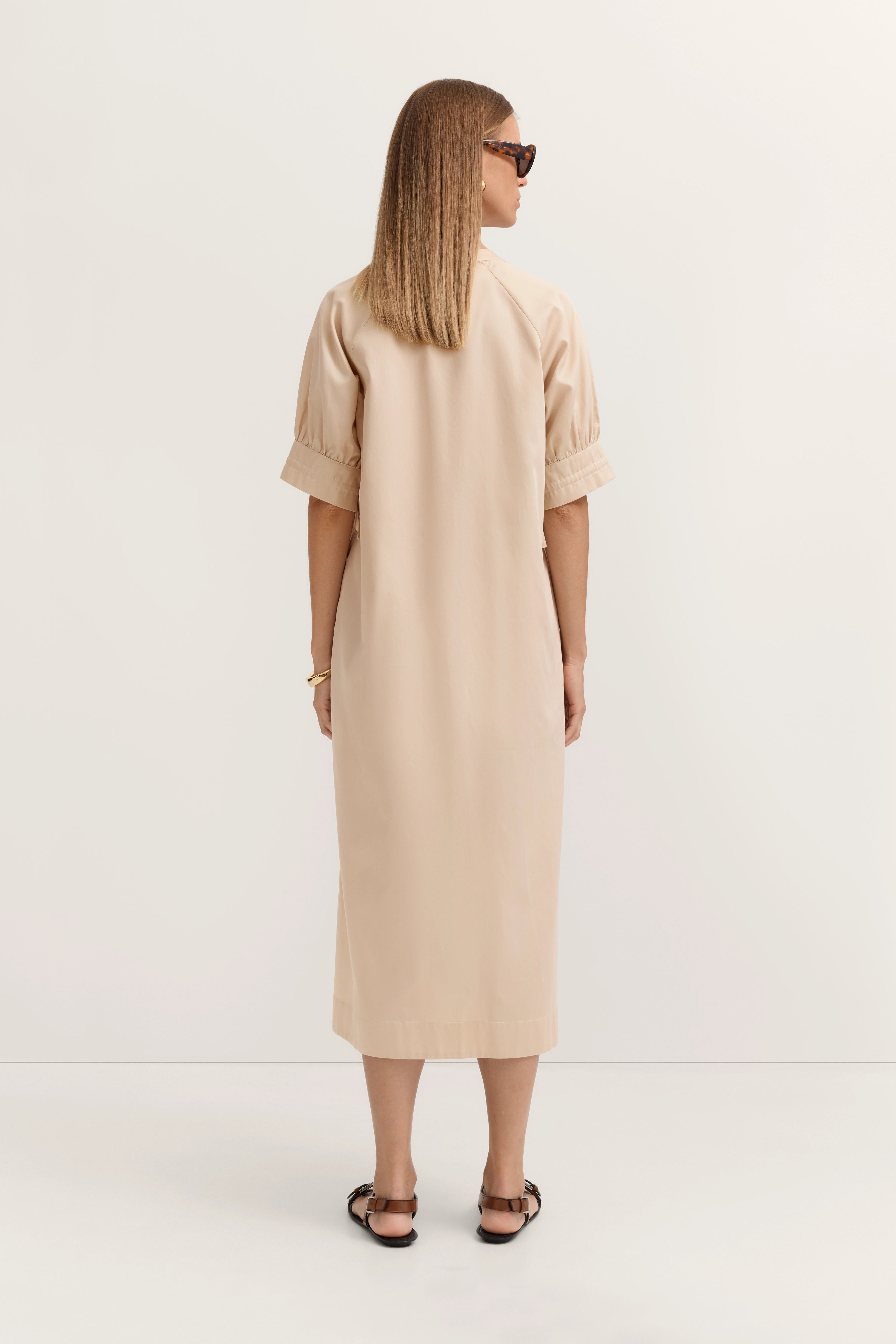 Beiges bugatti Kleid, Rückansicht, Midi-Länge, legeres Modelbild mit Sandalen.