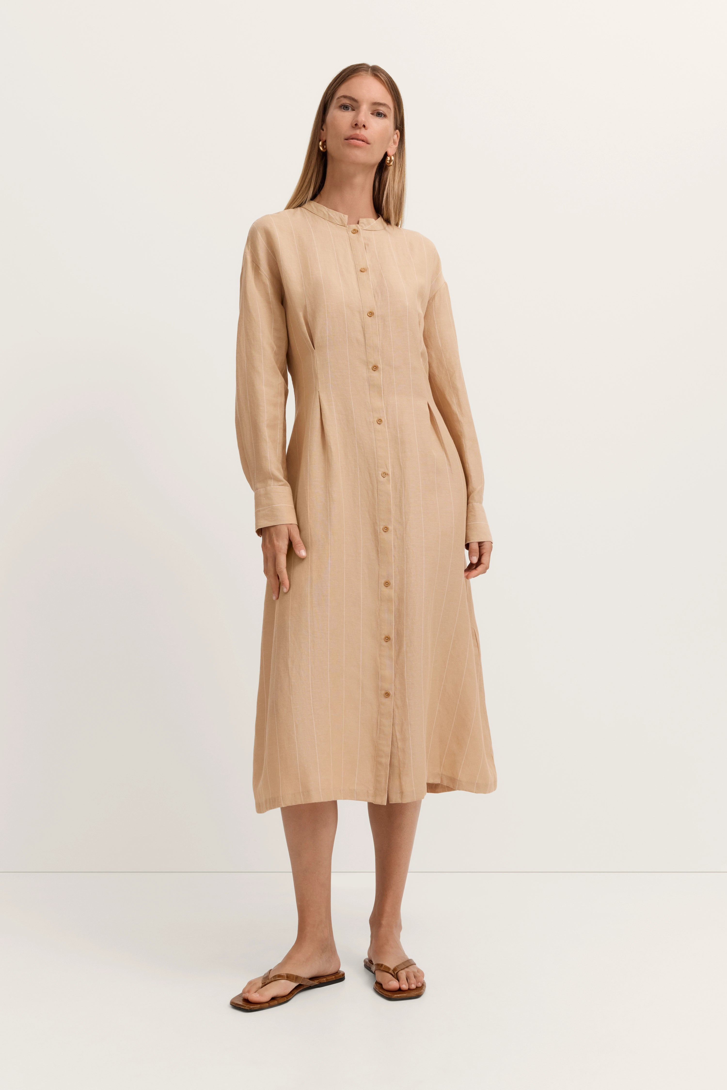 Beiges Hemdkleid mit langen Ärmeln, Model stehend, entspanntes Posing, bugatti Stil.