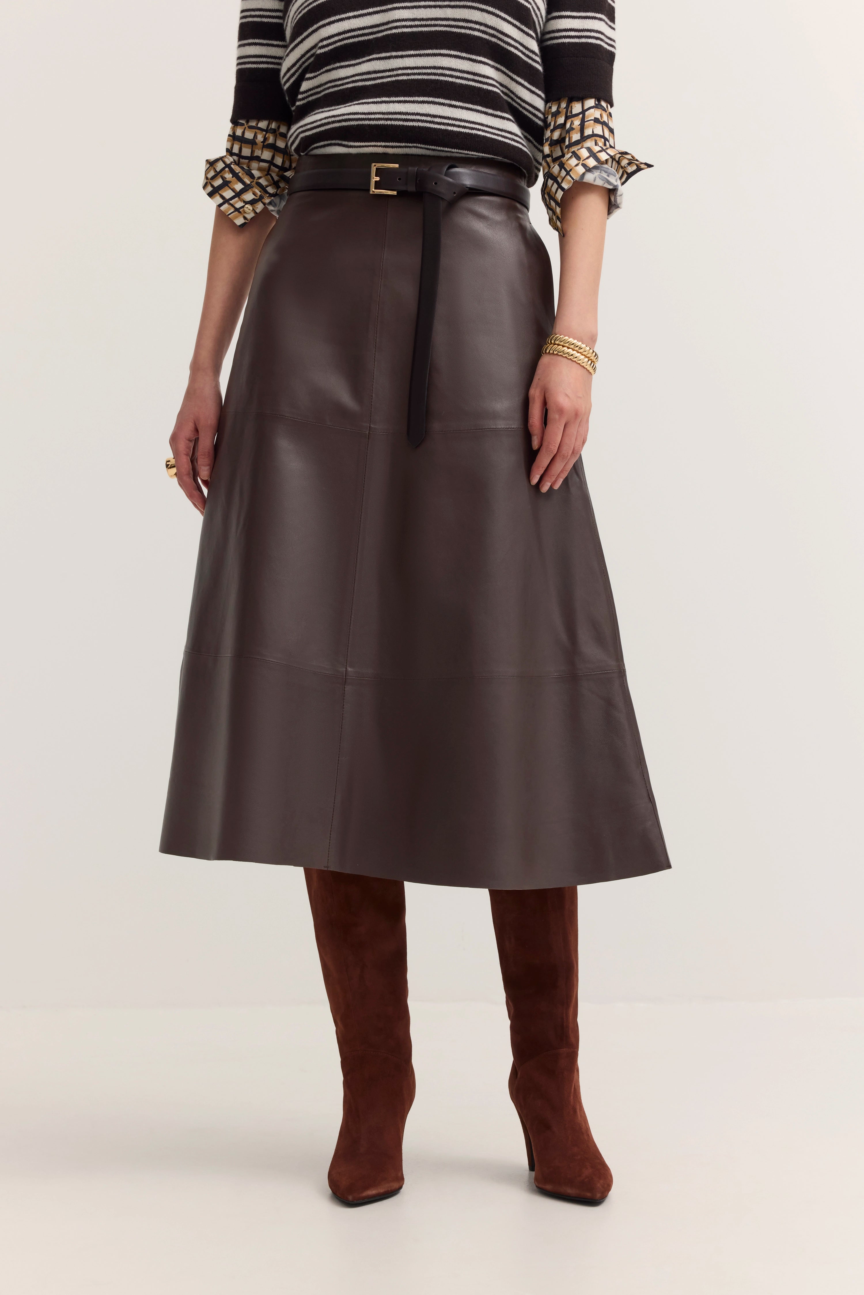 Damenoutfit mit gestreiftem Oberteil, braunem Ledergürtel und Rock. Modelbild, stehende Pose.
