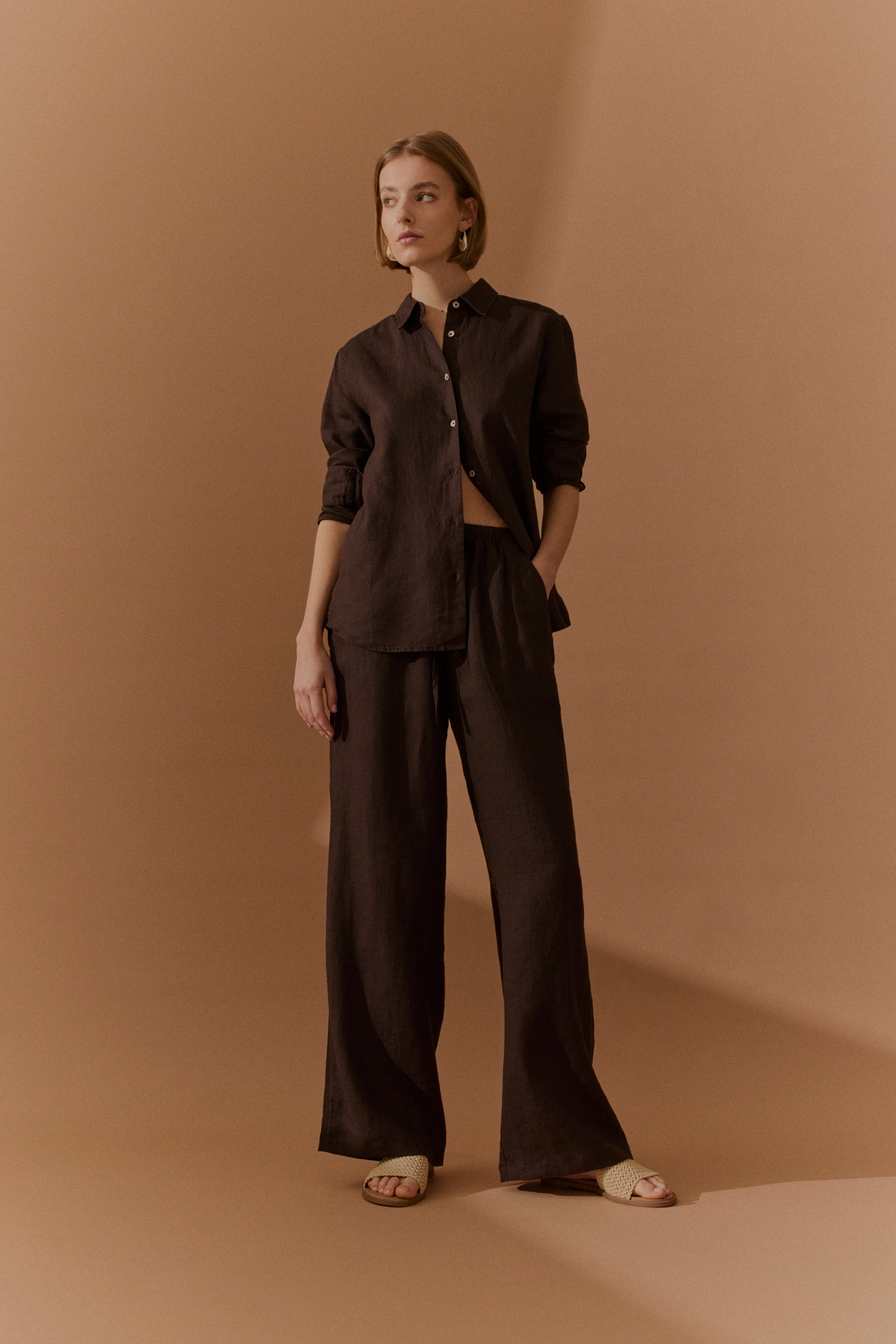 Braunes Leinenhemd und Hose, Model posiert lässig, bugatti Stil.