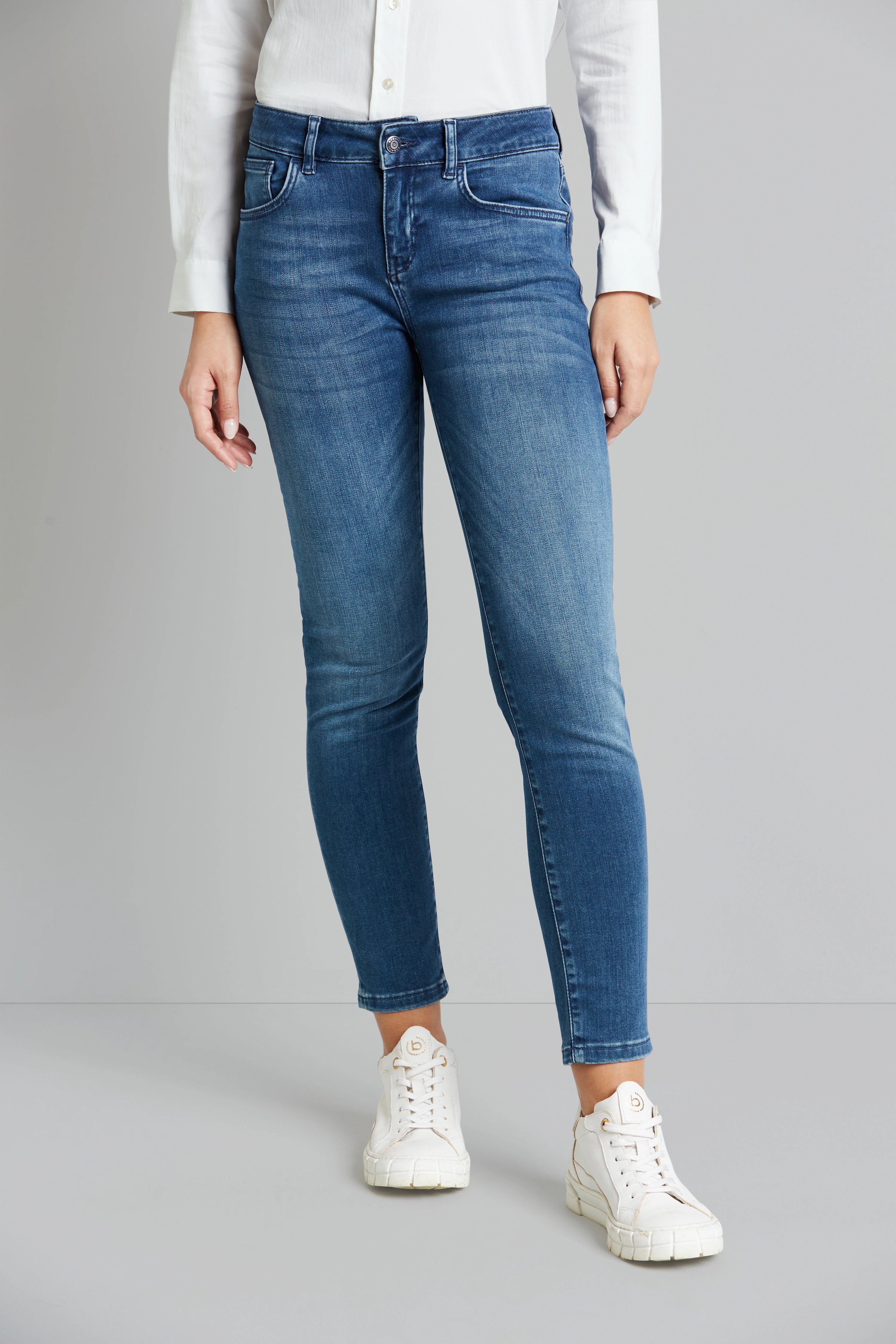 Weiße Bluse, blaue Jeans, weiße Sneaker
